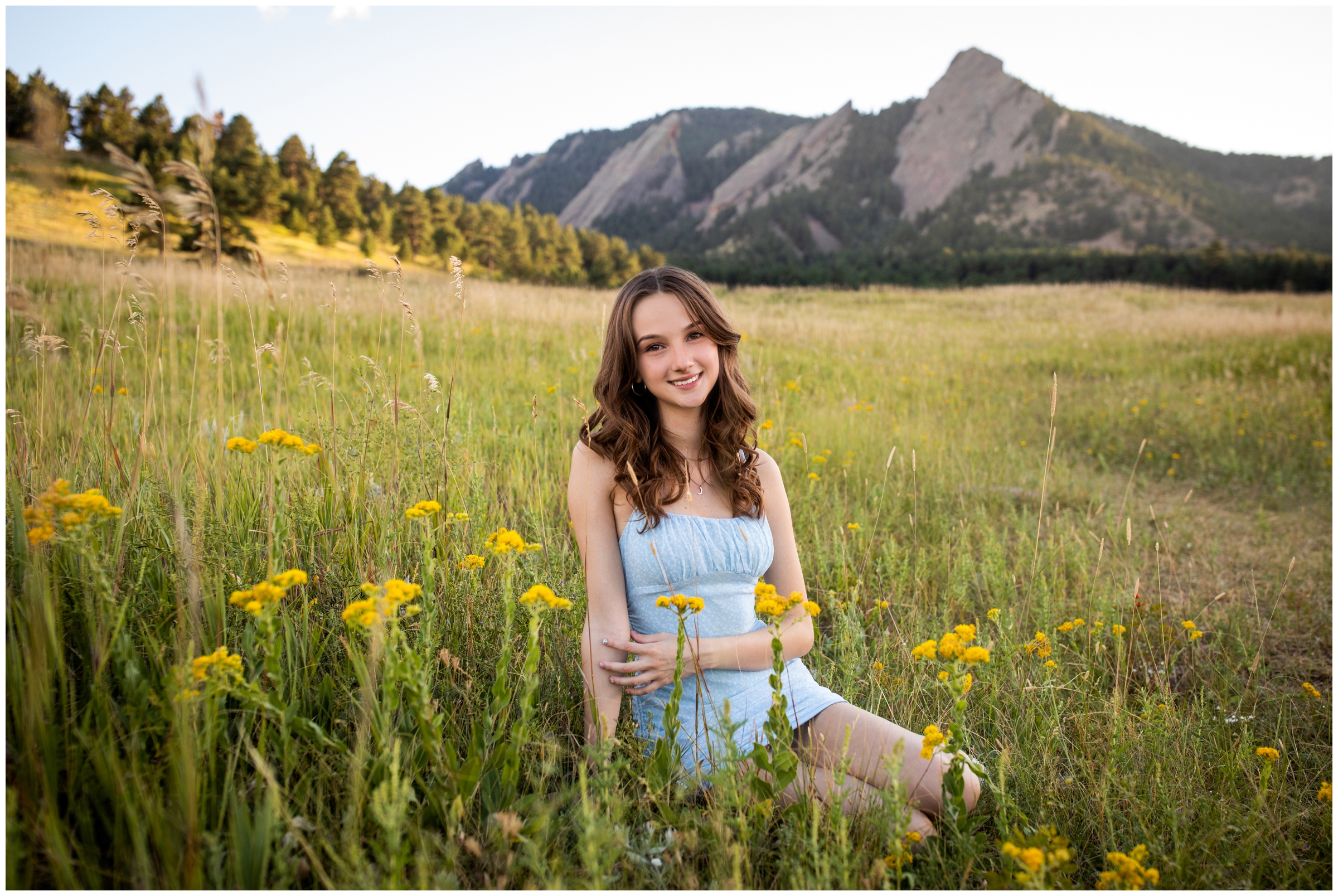 teen girl sitting in field of wildflowers during Boulder Colorado senior pictures at Chautauqua Park 