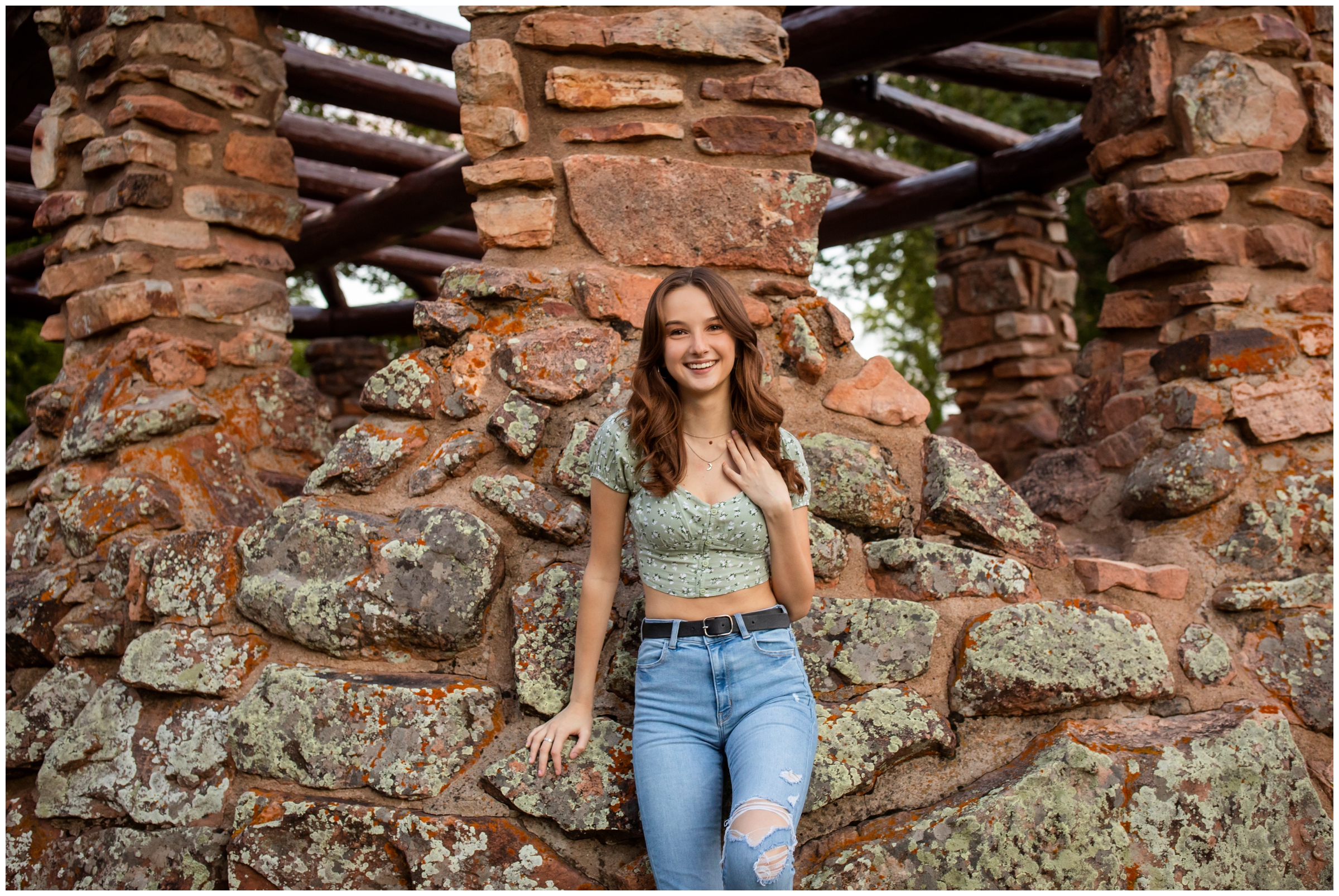 teen posing on stone structure during Colorado summer senior photography session