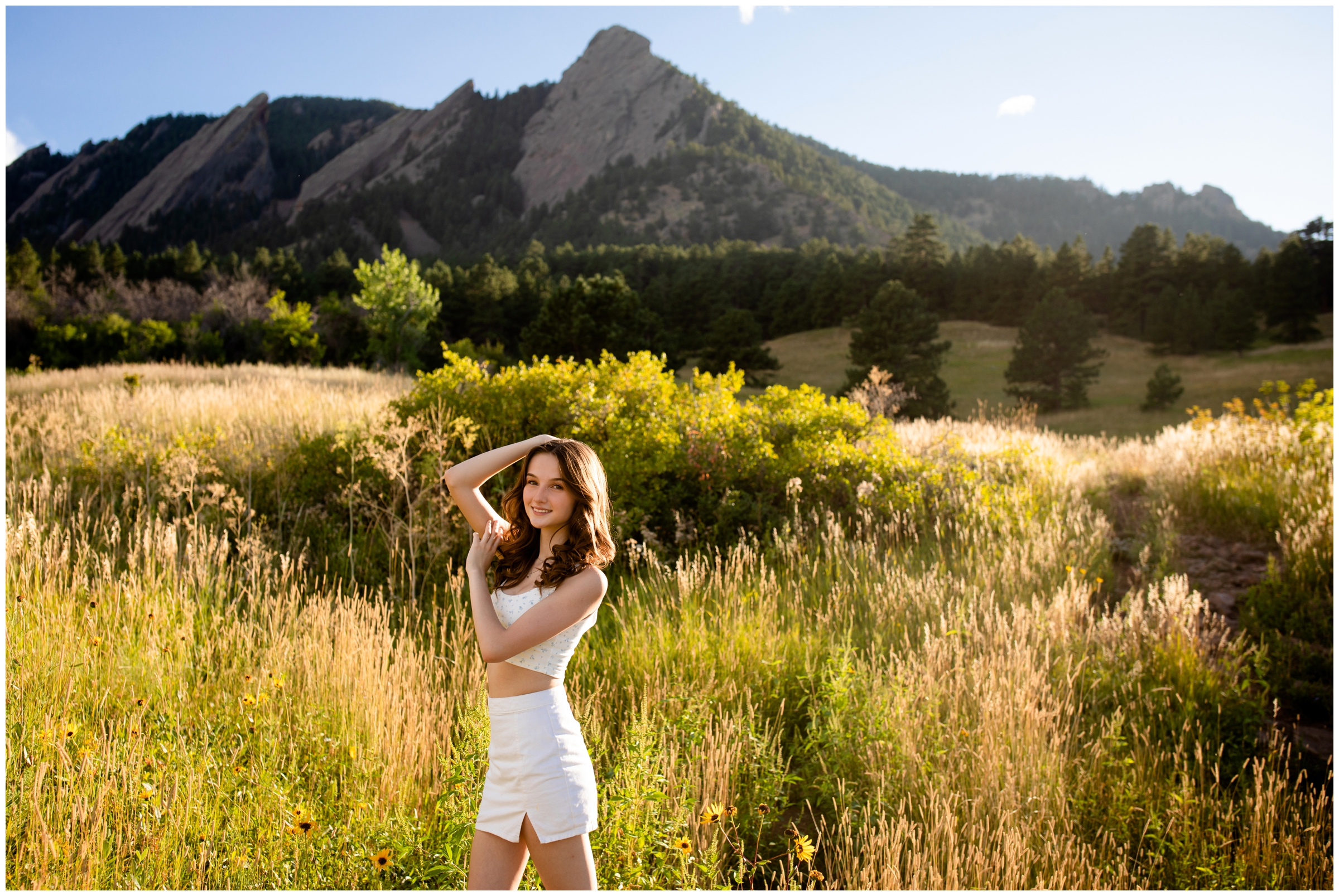 teen posing with flatirons mountains in background at senior pictures in Boulder Colorado 