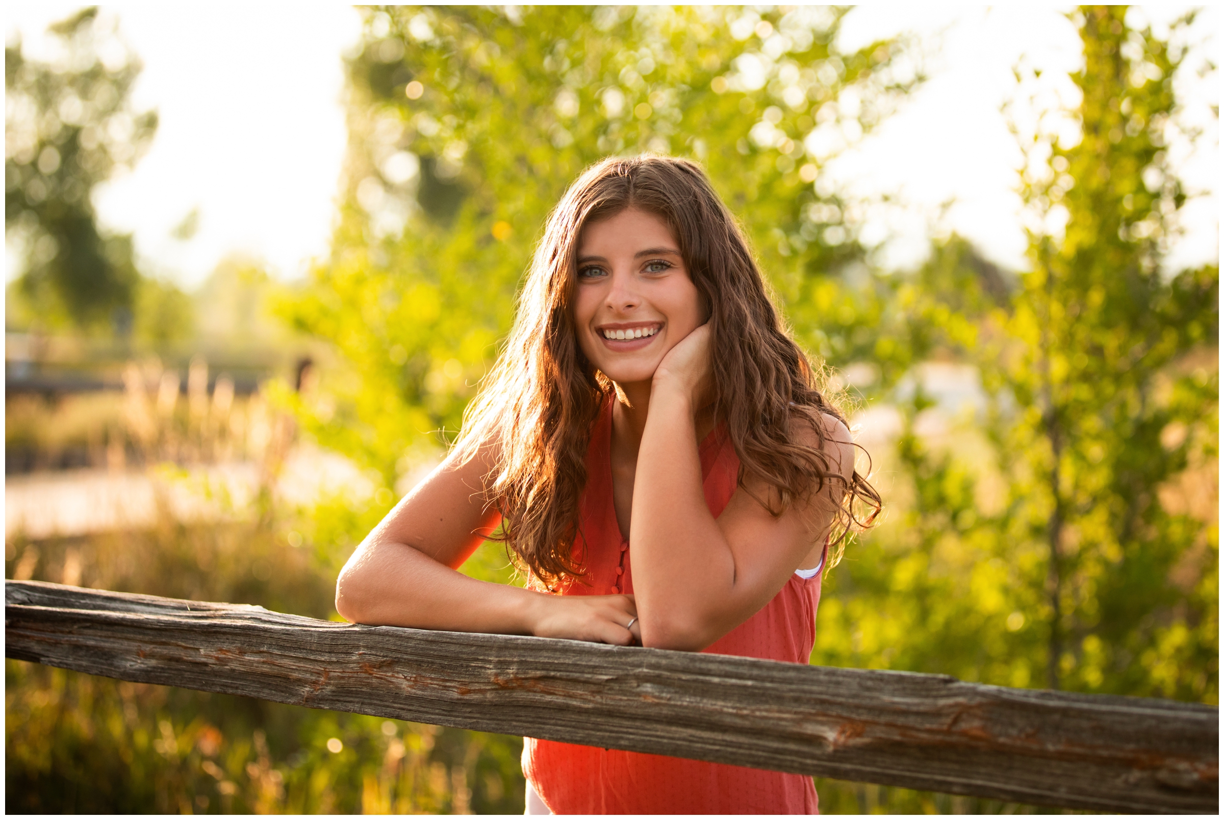 teen leaning on fence during senior photos in Longmont Colorado 