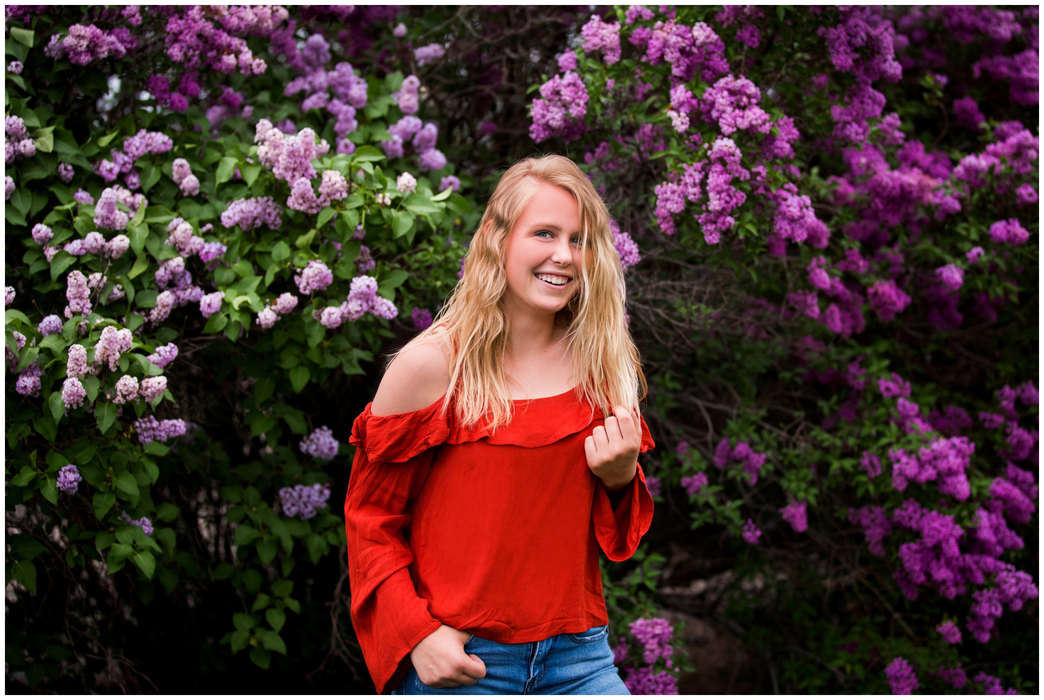 Longmont high senior pictures with lilac bushes in the background during spring portrait session