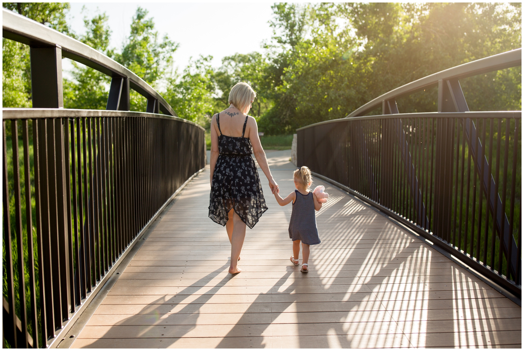 mom and daughter walking on bridge at Loveland family photos at Chapungu Sculpture Park