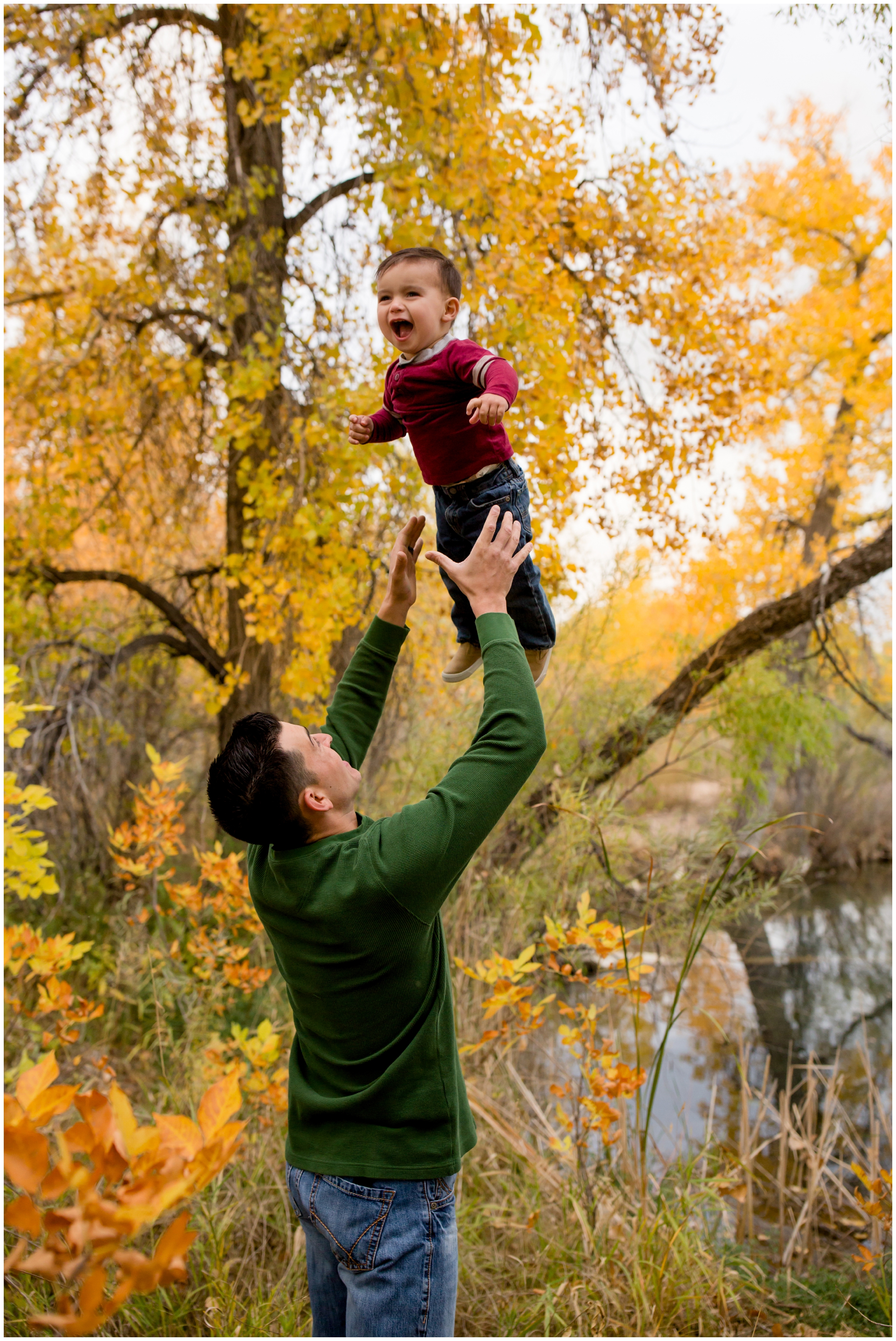 father throwing son in air during fall Fort Collins Colorado family portraits at Riverbend Ponds 