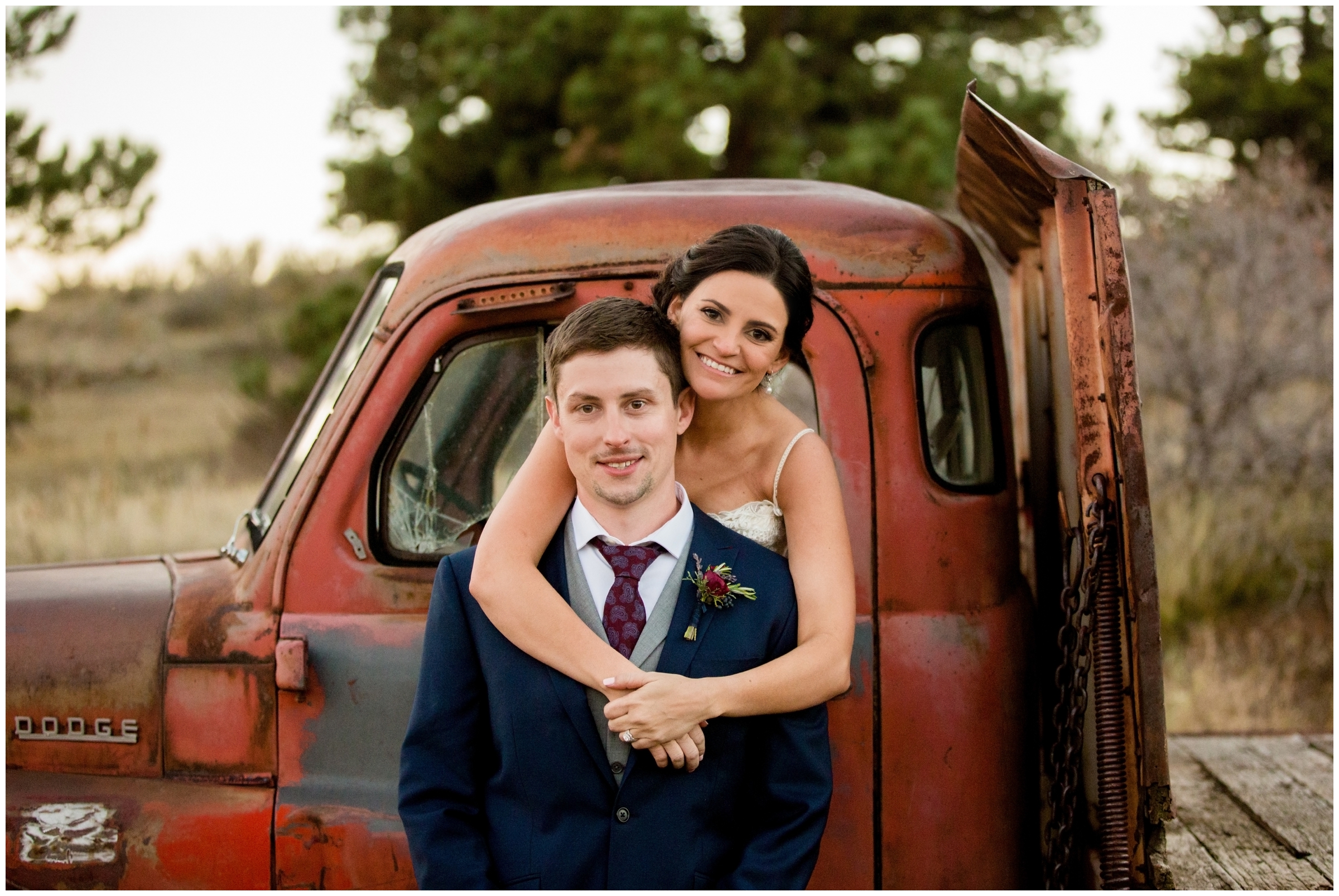 couple posing with old truck at Lyons Colorado rustic wedding 