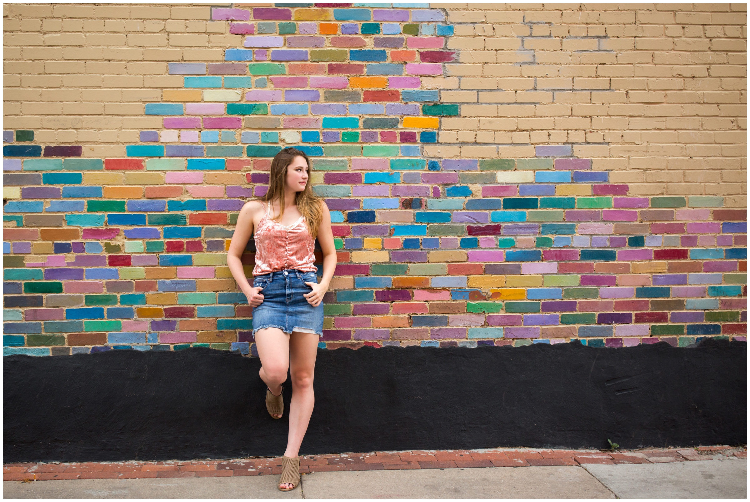 silver creek high longmont senior standing against colorful brick wall on Pearl Street Mall Boulder 