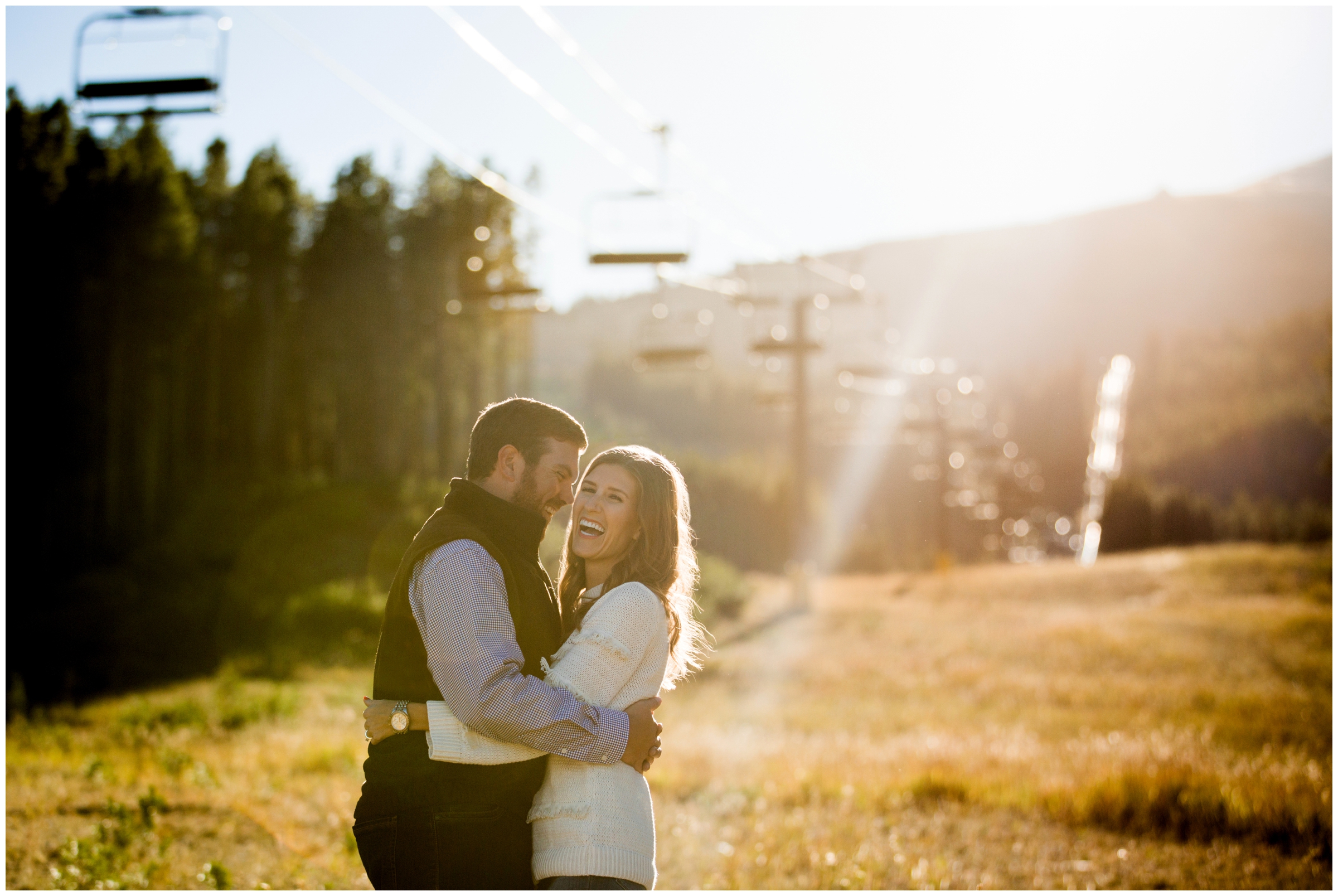 woman laughing during Breckenridge Colorado engagement photographs at ski resort with chairlifts in background