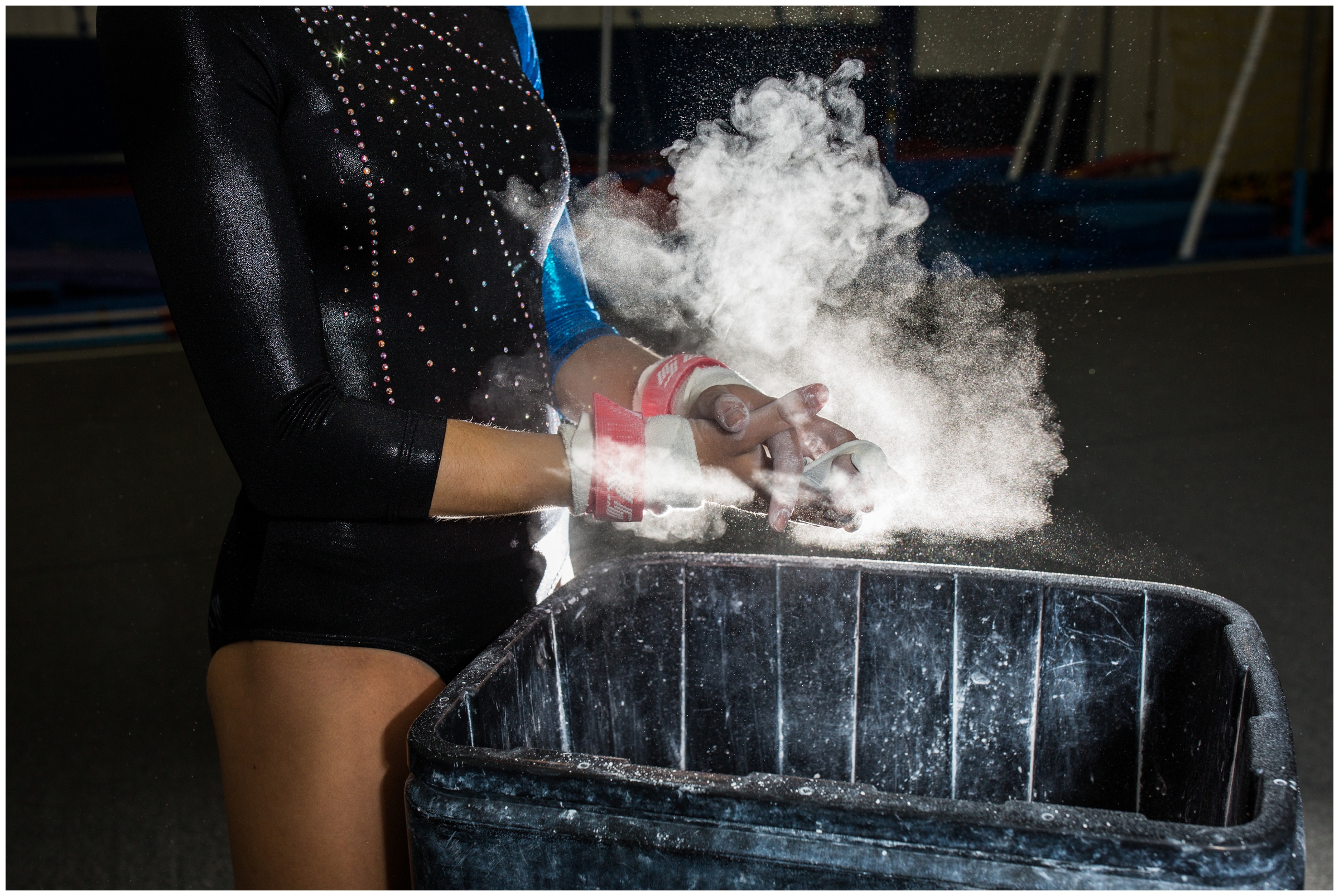 gymnast putting chalk on hands during gymnastics senior portraits 