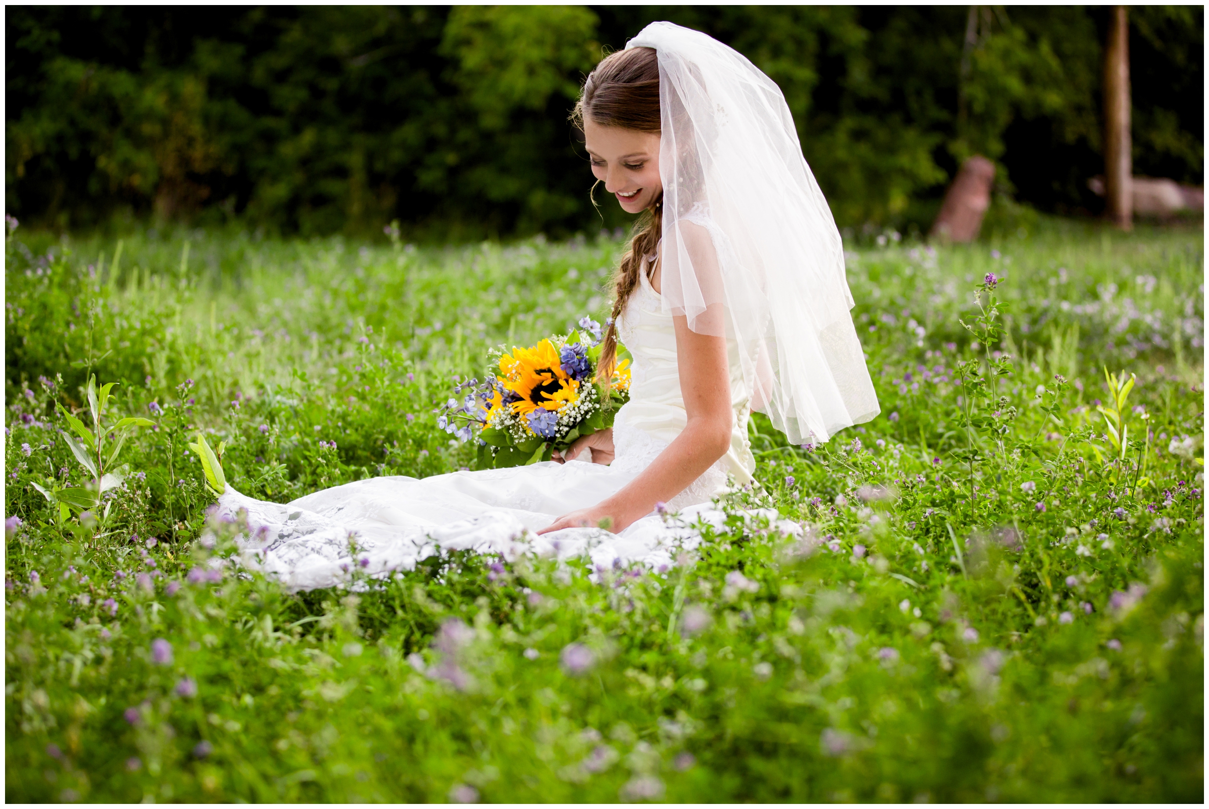 bride sitting in wildflowers at Golden Colorado summer wedding