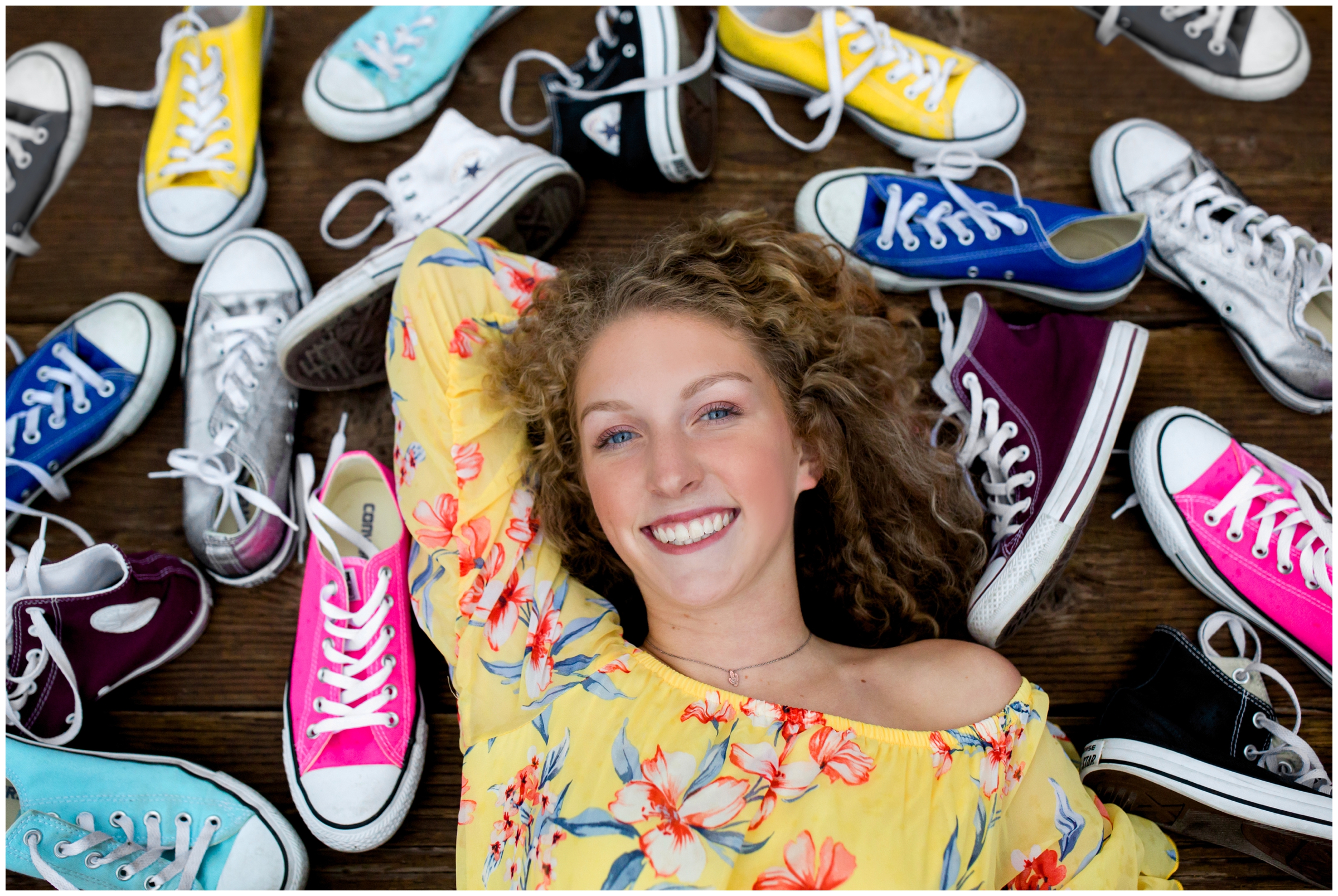 teen girl laying with converse shoes around her at Mead senior pictures by Plum pretty Photo