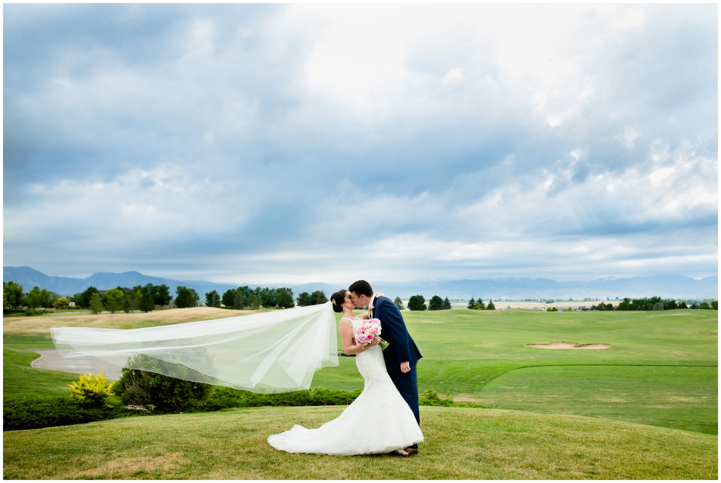 couple kissing with mountains in background at Colorado National Golf Club wedding