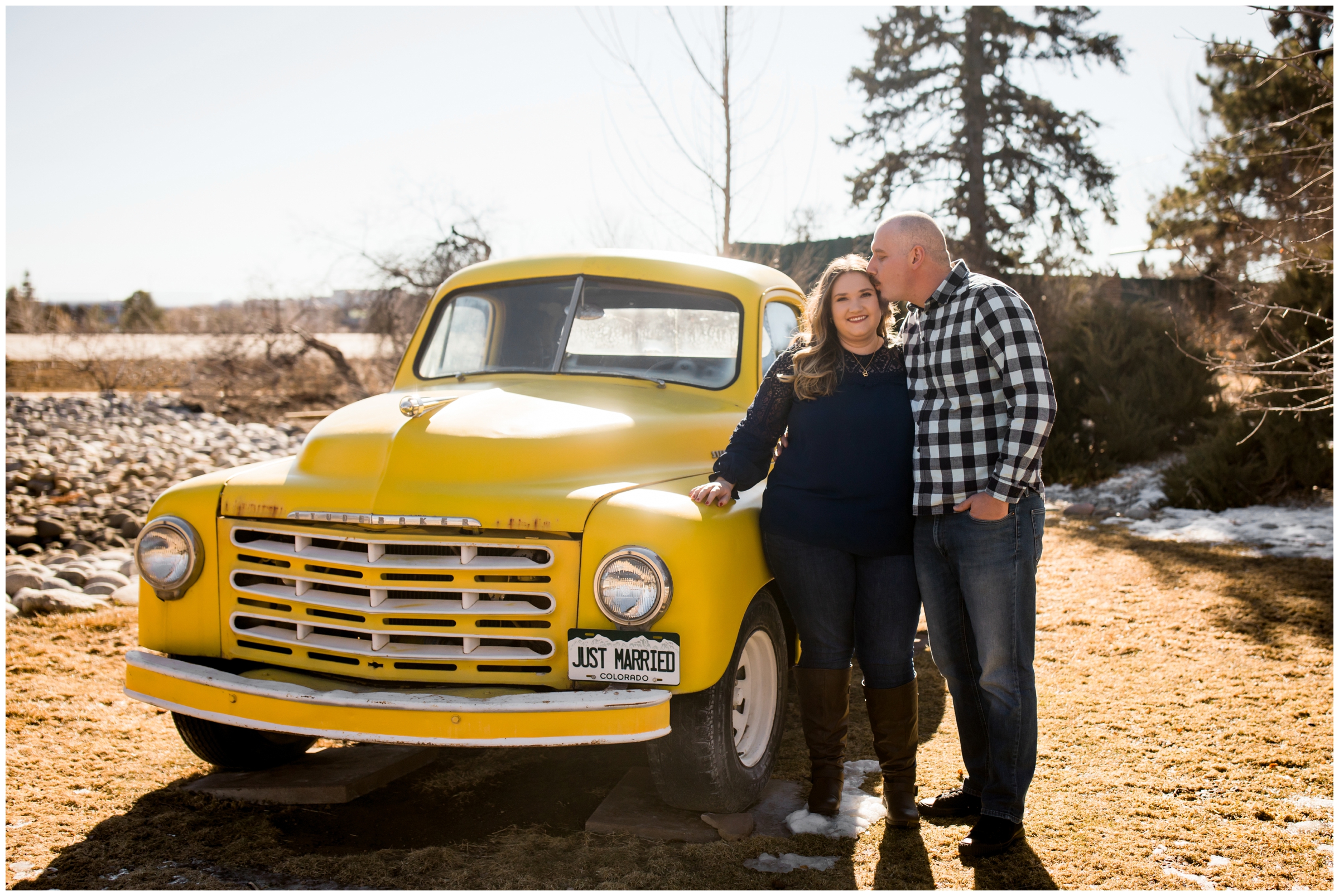 couple kissing in front of vintage yellow truck during Colorado engagement pictures 