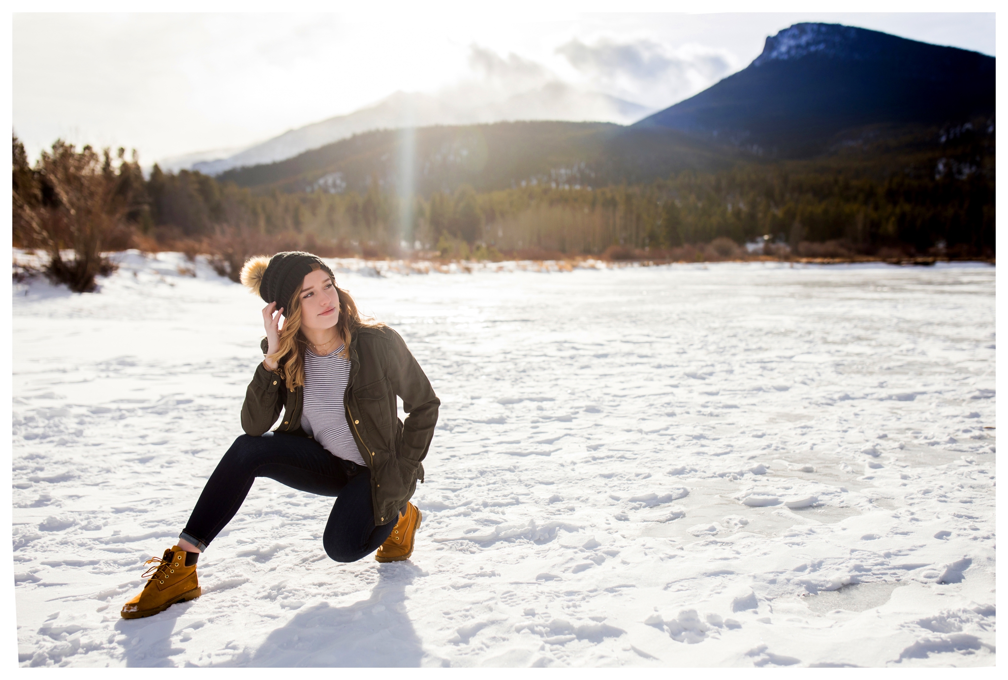 teen girl posing in snow with mountains in background at Colorado winter senior photos