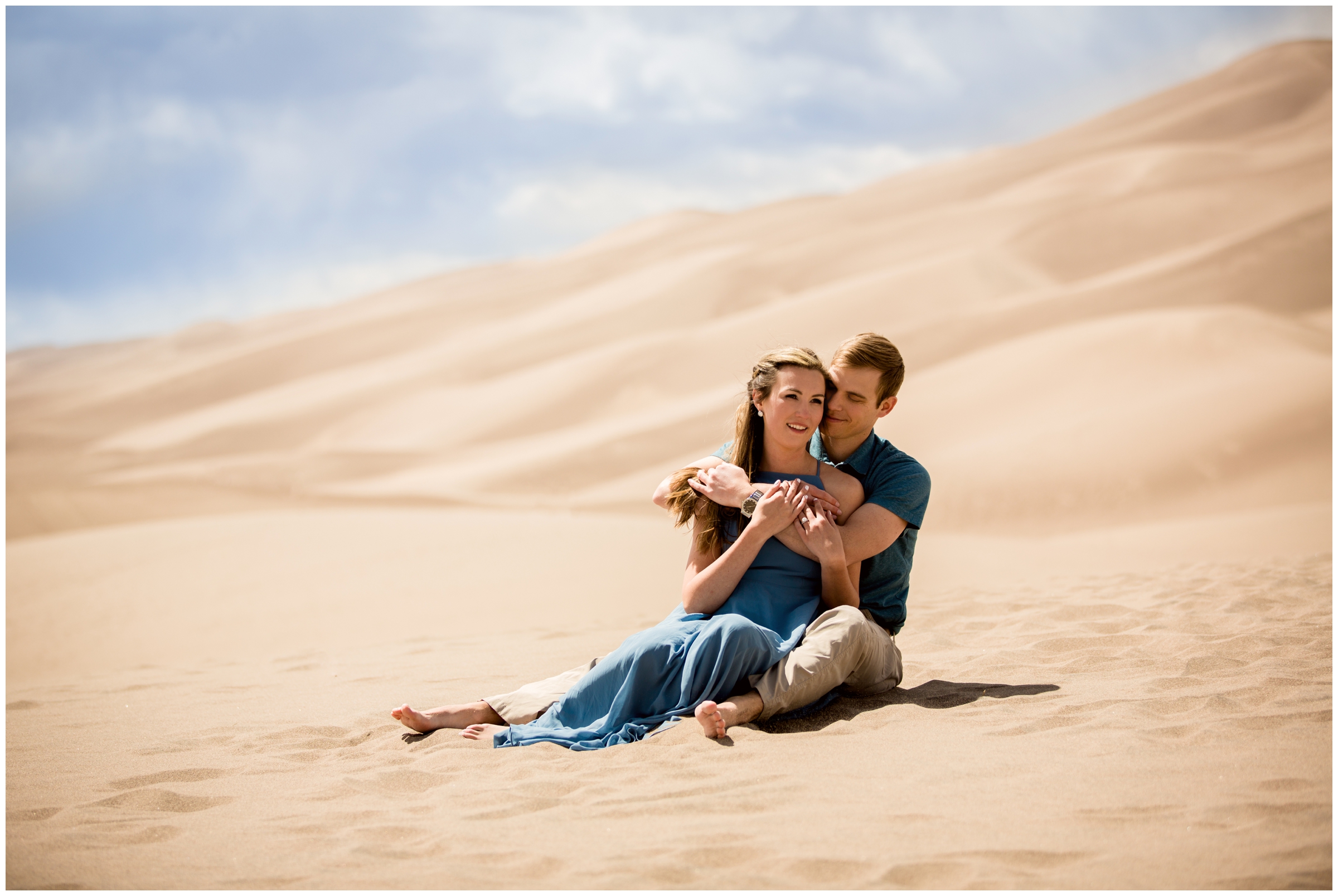 couple sitting in the sand dunes during Colorado adventure engagement photography session 