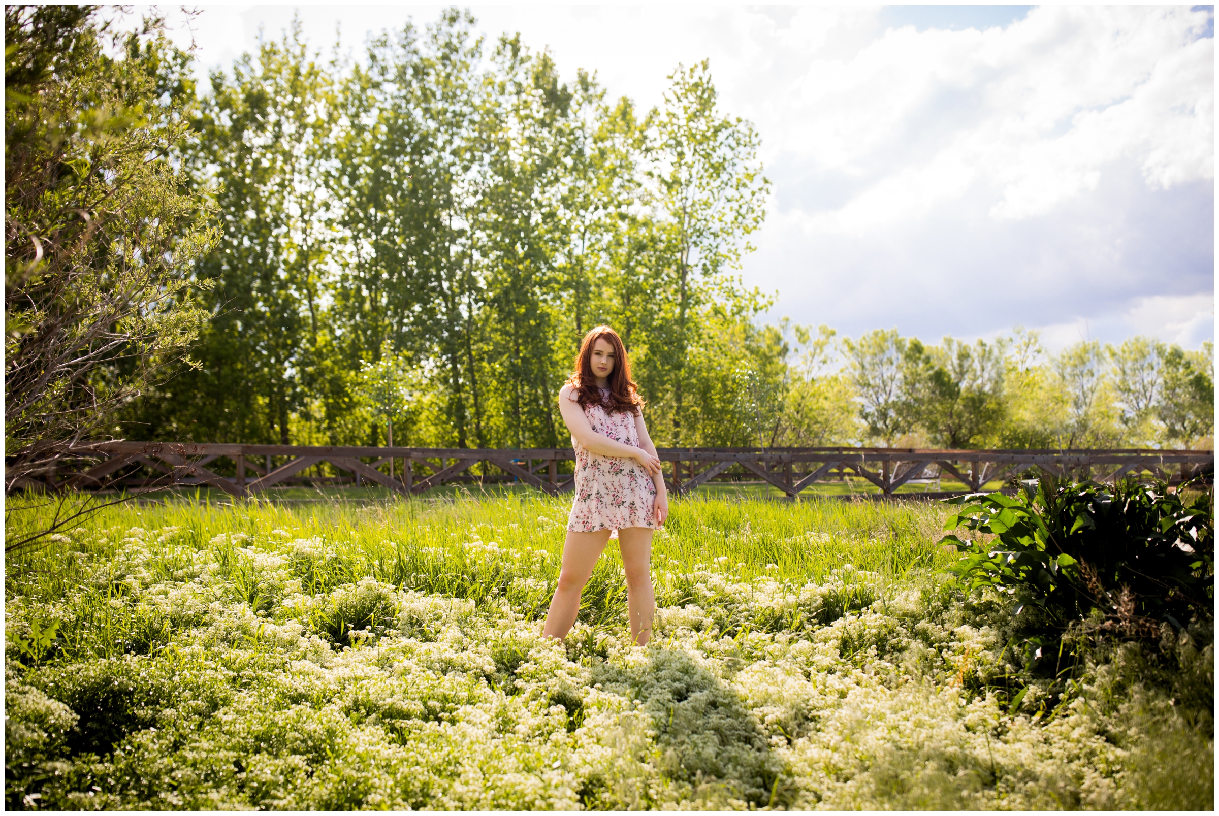 teen standing in a field of white flowers during Erie Colorado senior pictures 