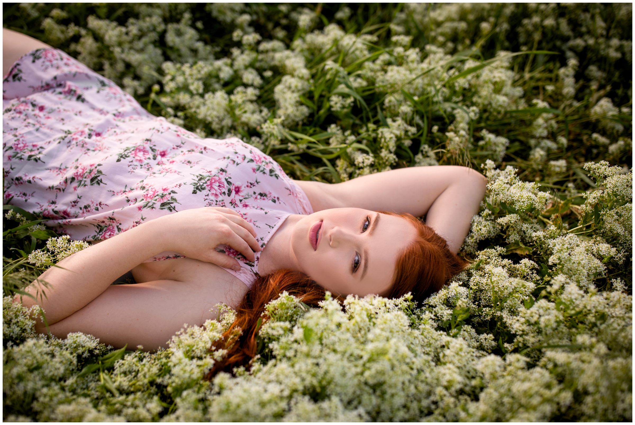 redhead laying in a field of flowers during her Erie senior photos by Colorado portrait photographer Plum Pretty Photography