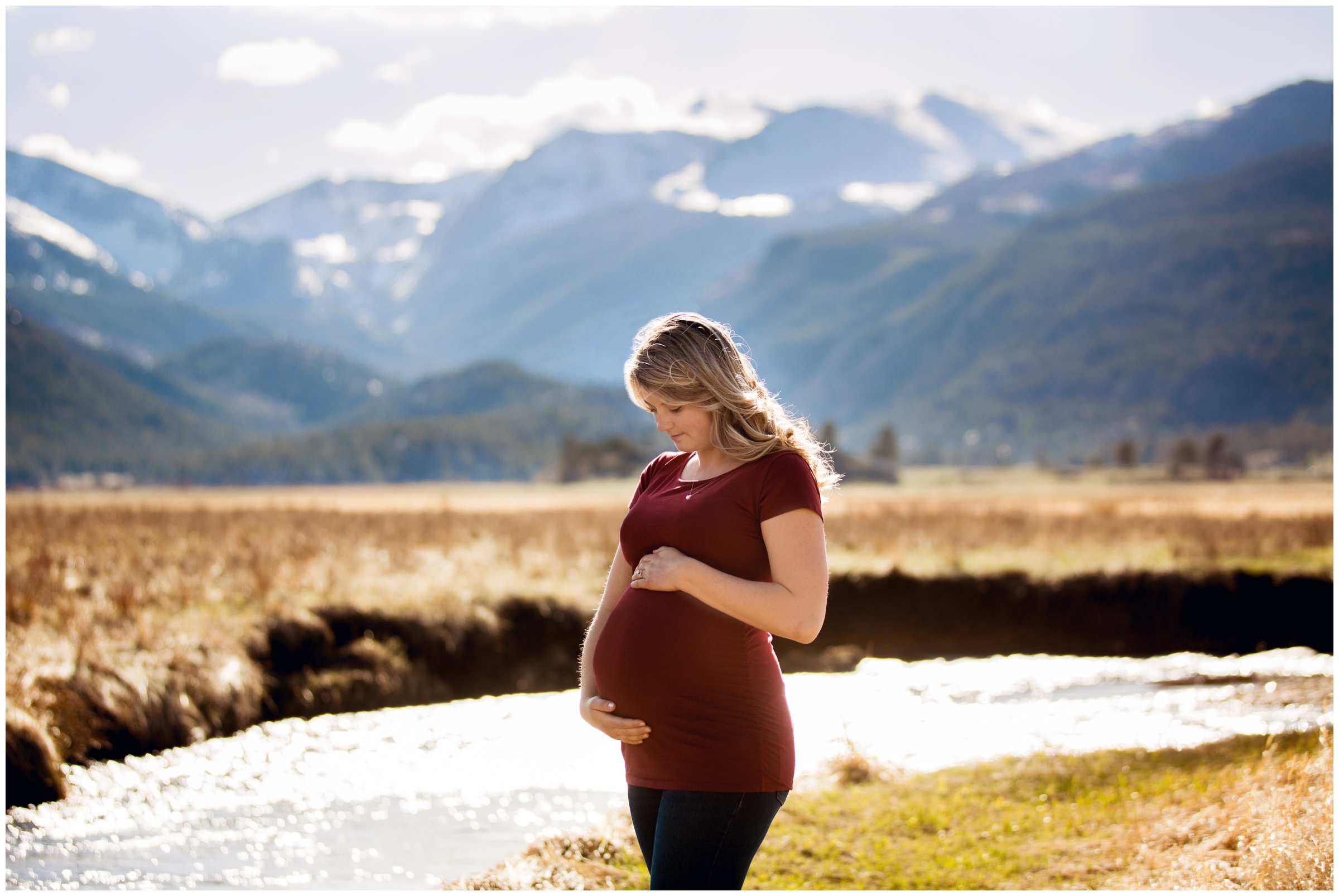 pregnant woman holding her belly at Moraine Park in RMNP during maternity portraits 