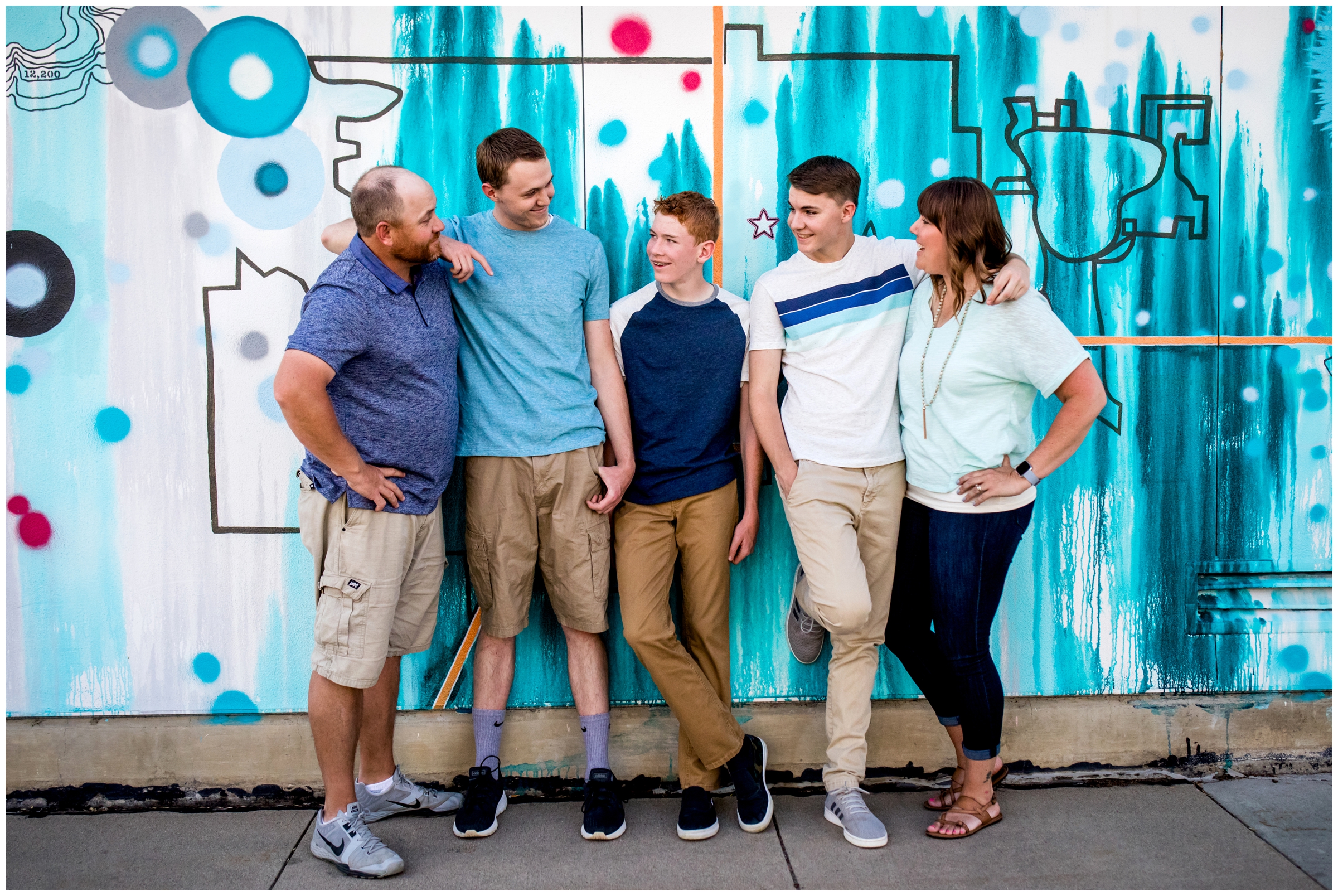family posing against urban graffiti wall during their Longmont Colorado family pictures 