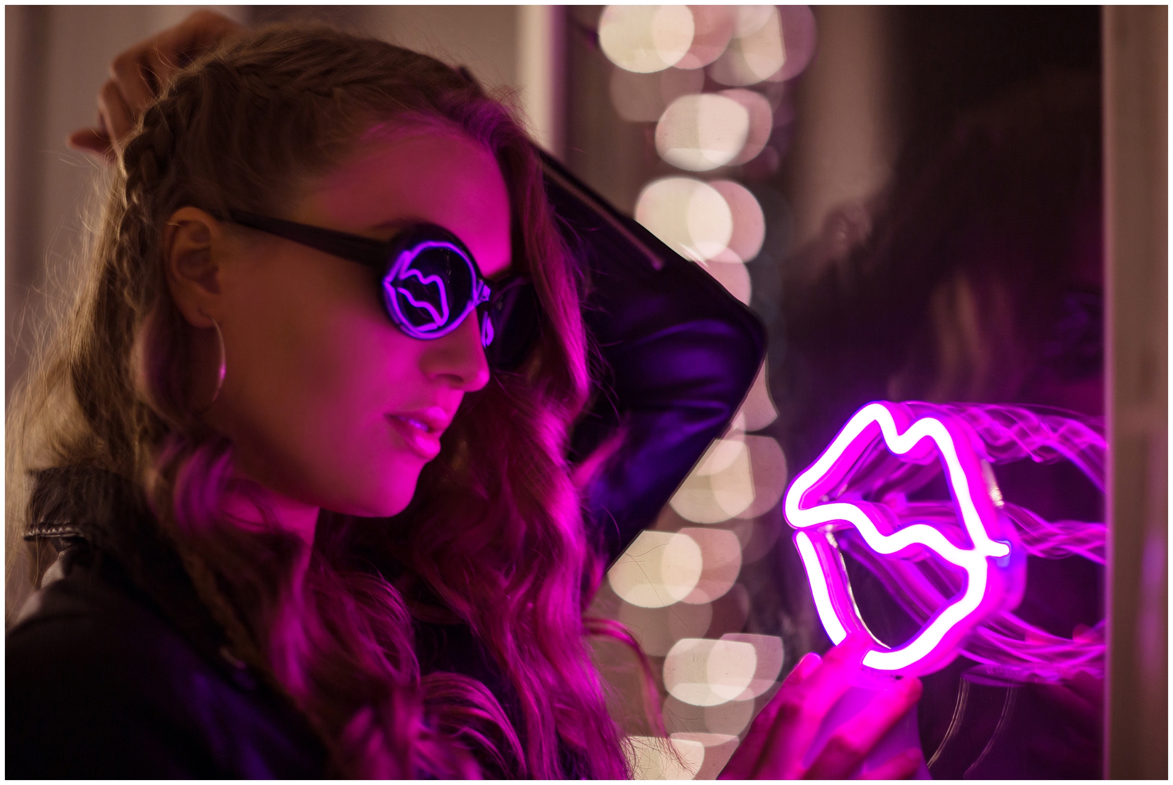 teen holding neon sign during creative Colorado night senior photos in Longmont