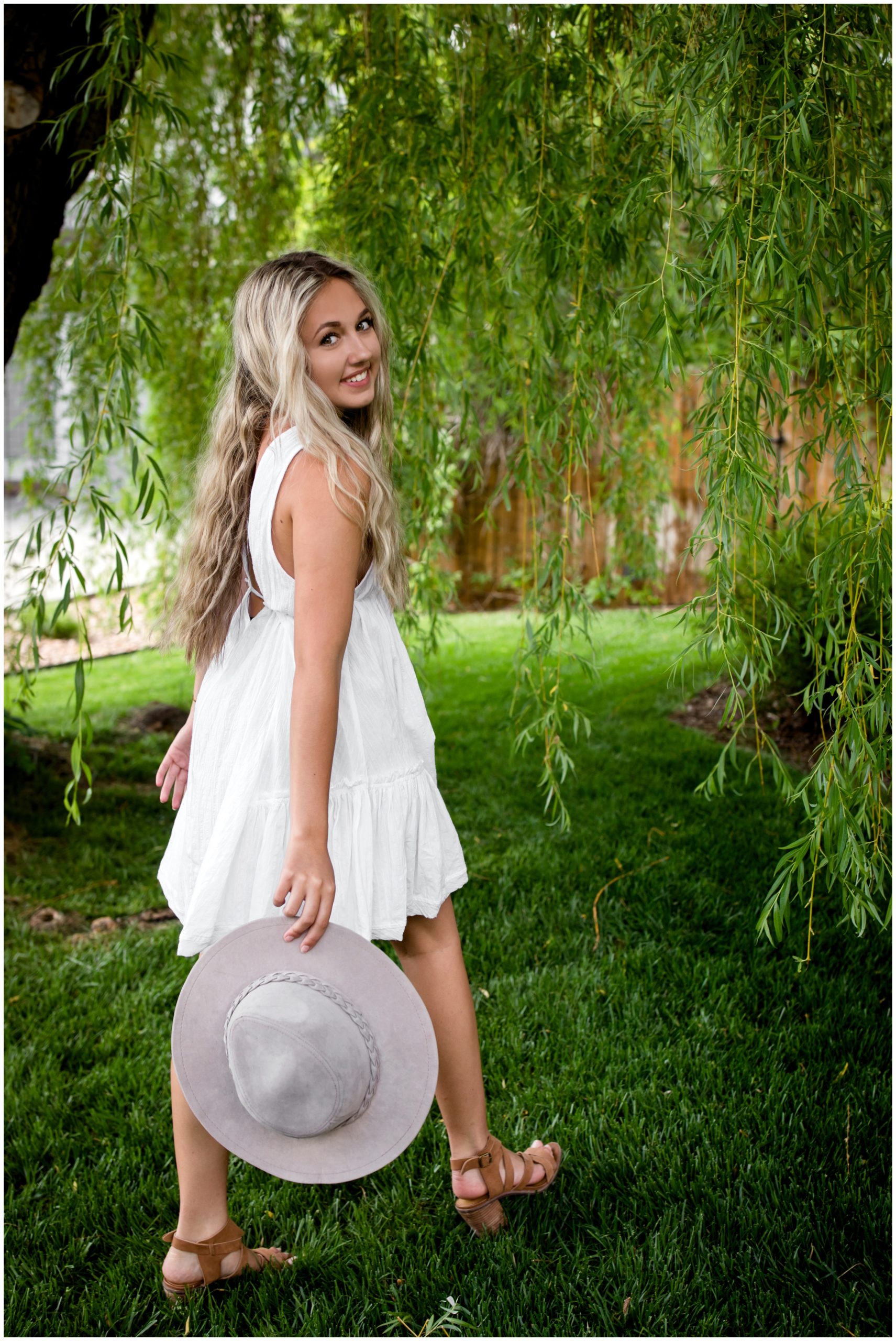 teen girl walking with gray hat during Broomfield senior pictures 