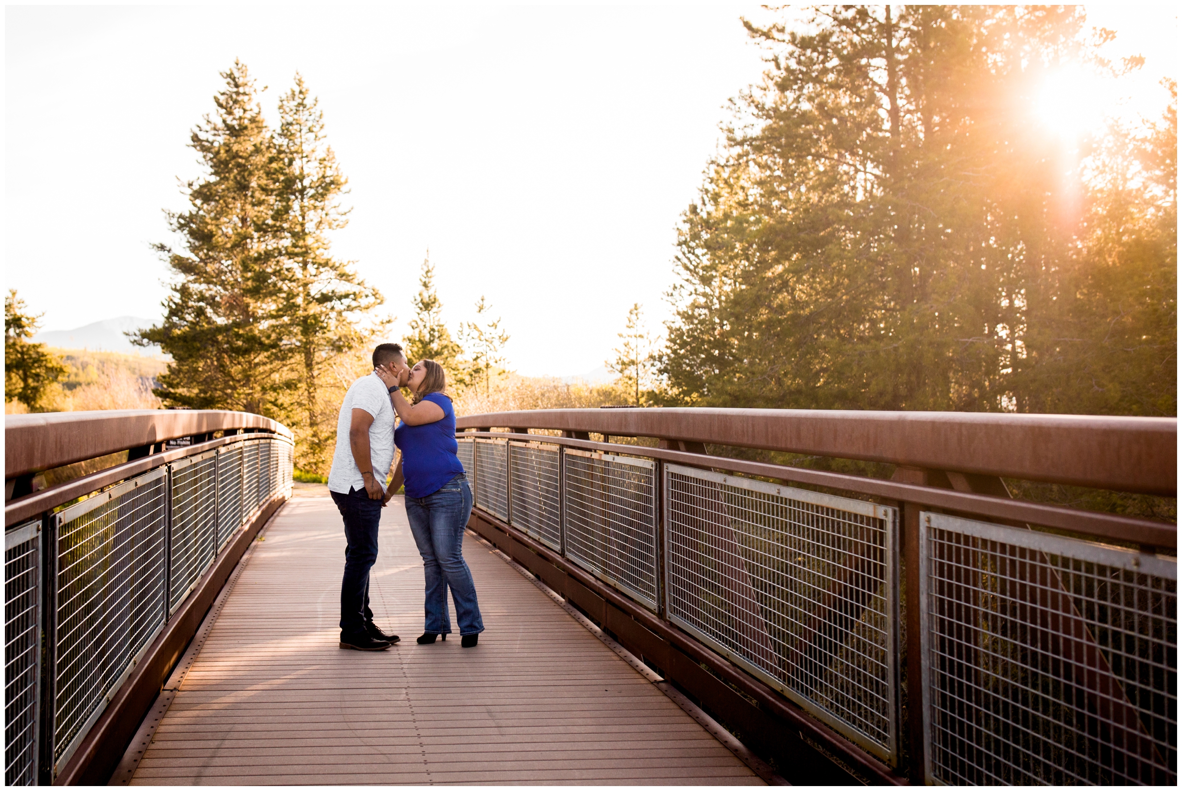 couple kissing on bridge during Winter Park Colorado engagement photography session 