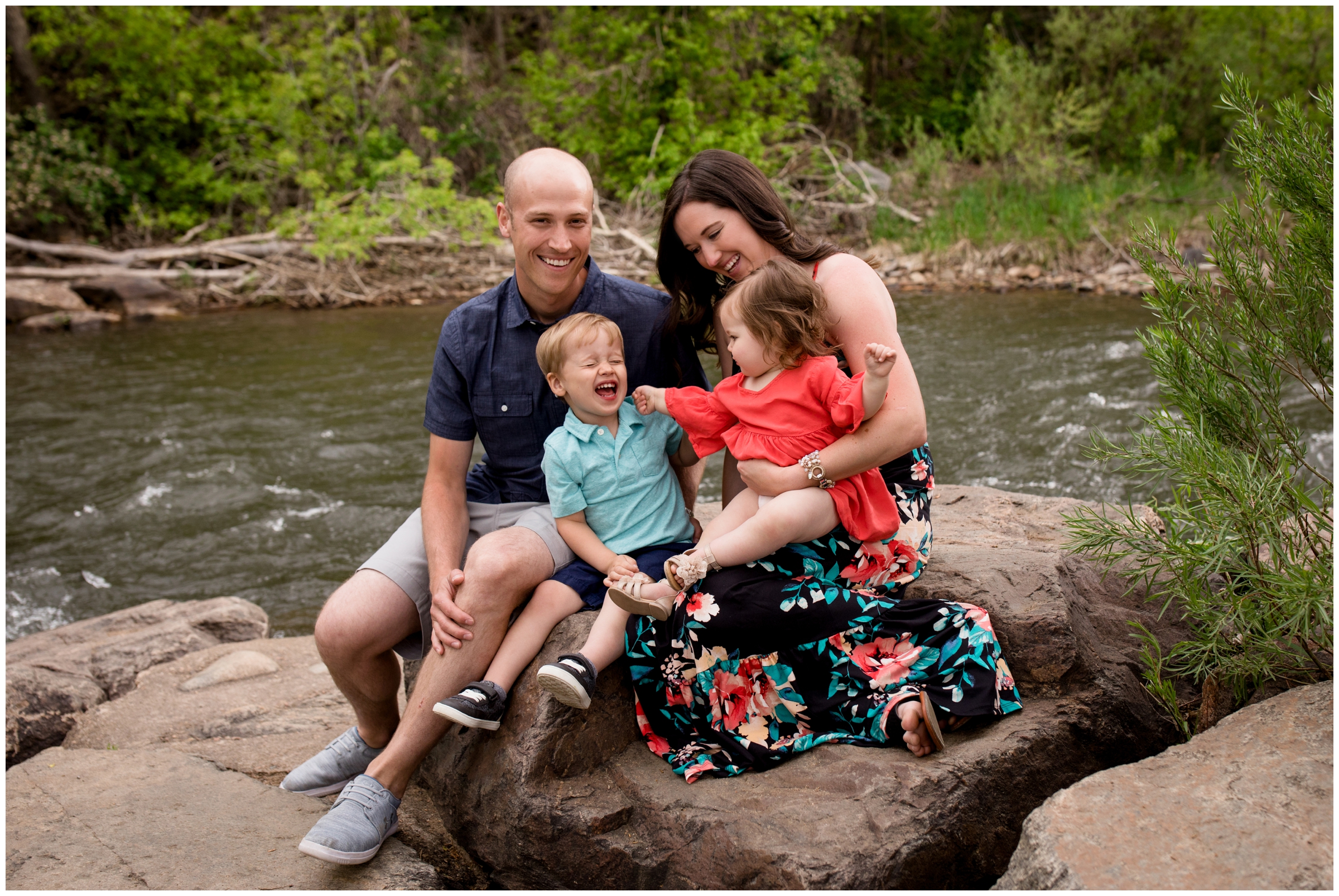 family of four sitting by river during Golden family photos at Golden History Museum by Colorado portrait photographer Plum Pretty Photography