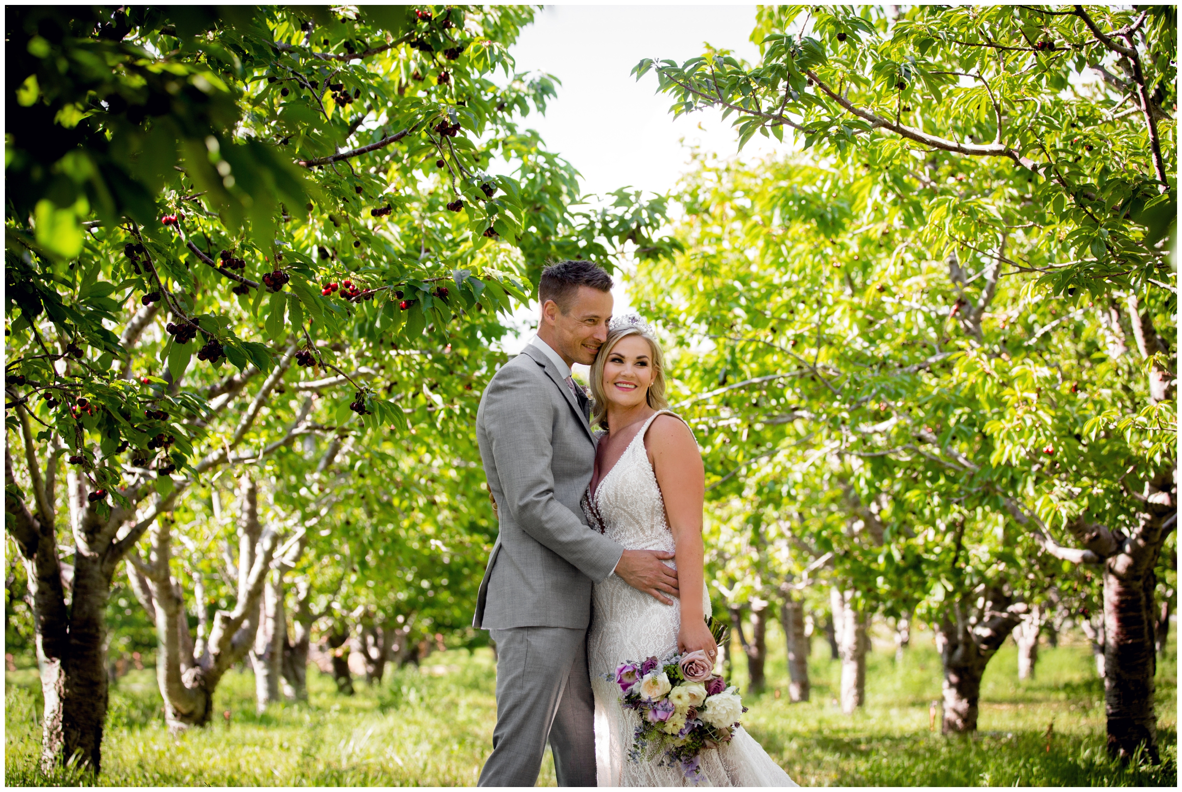 couple posing in cherry orchard during Palisade Colorado wedding portraits 