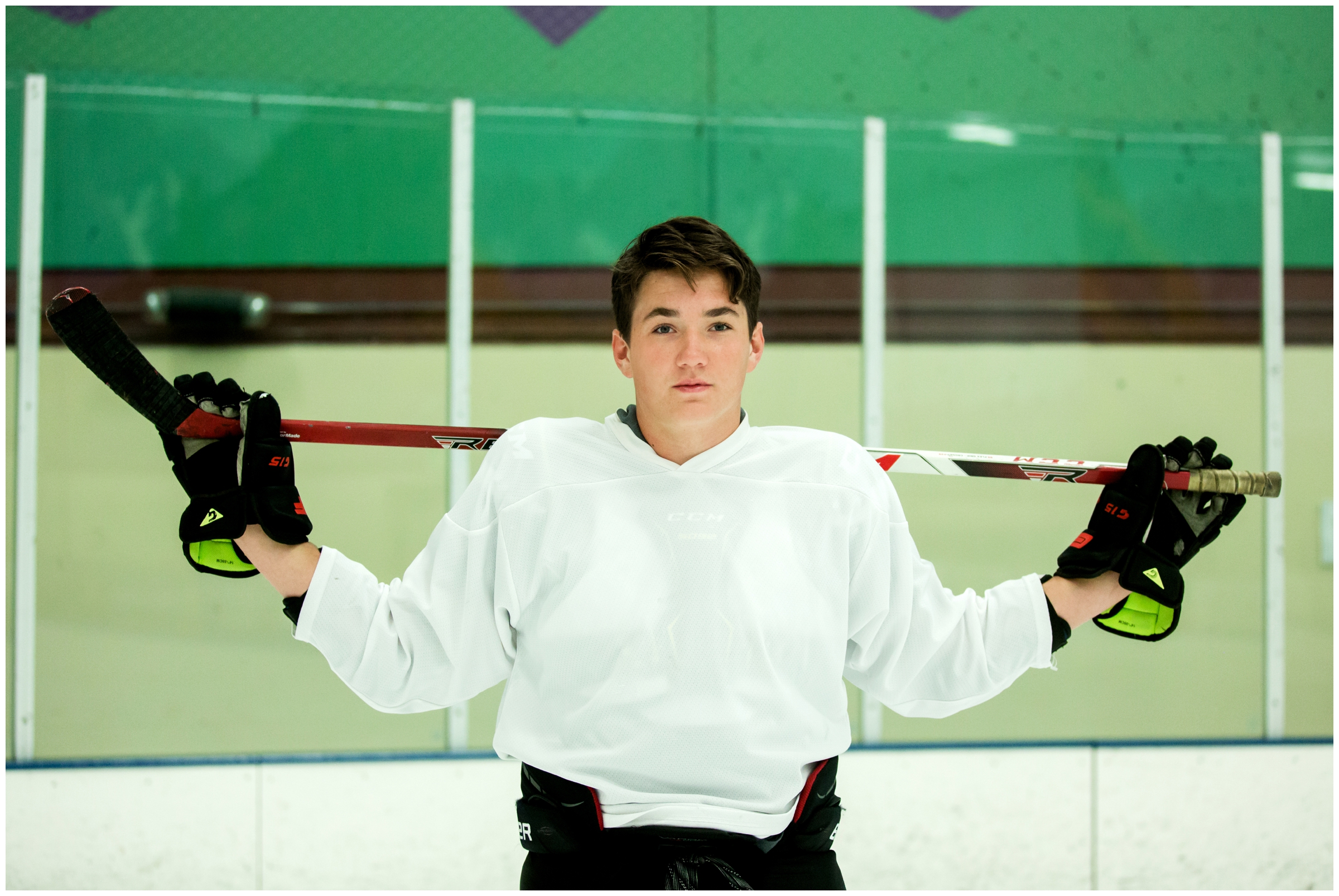 teen boy posing with hockey stick during Colorado senior photos