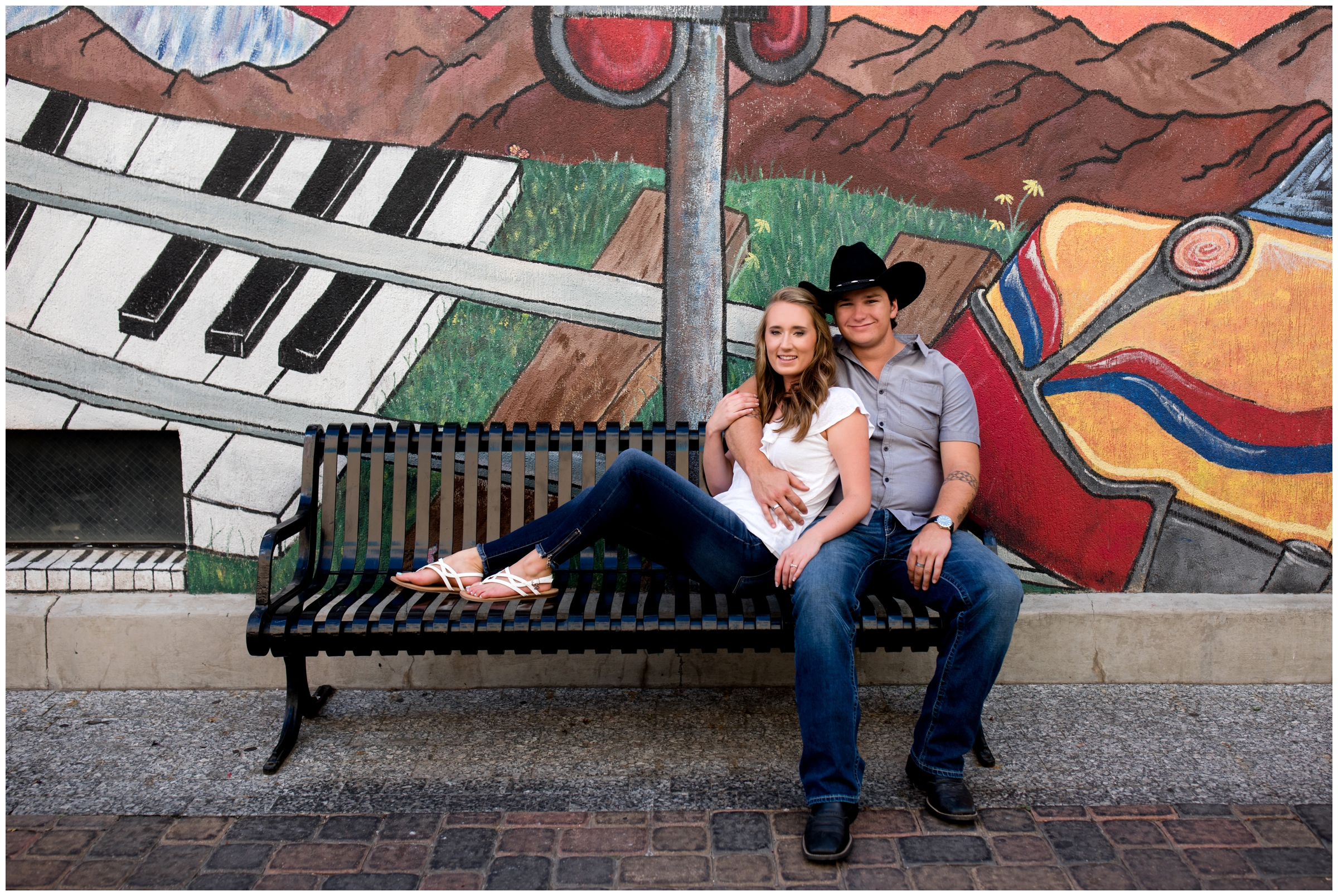 couple cuddling on bench during urban Colorado photo shoot 