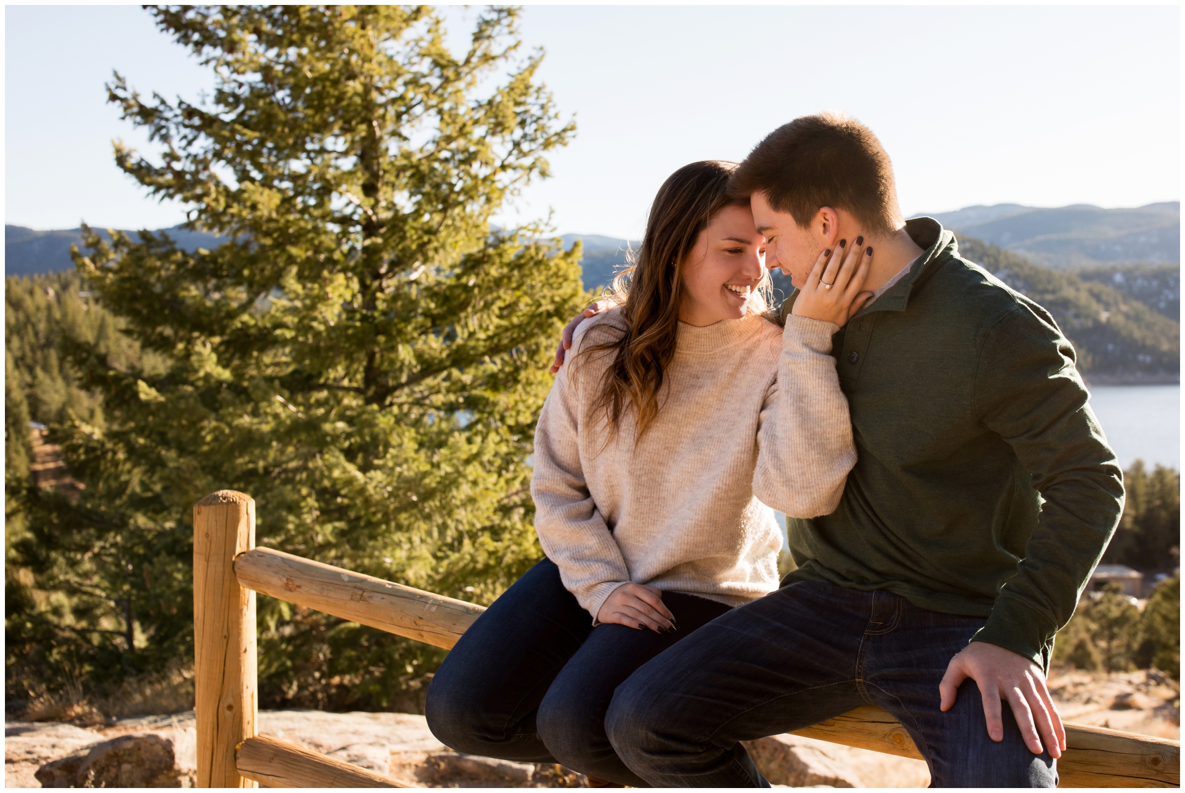 couple sitting on wooden fence during Boulder engagement photography session 