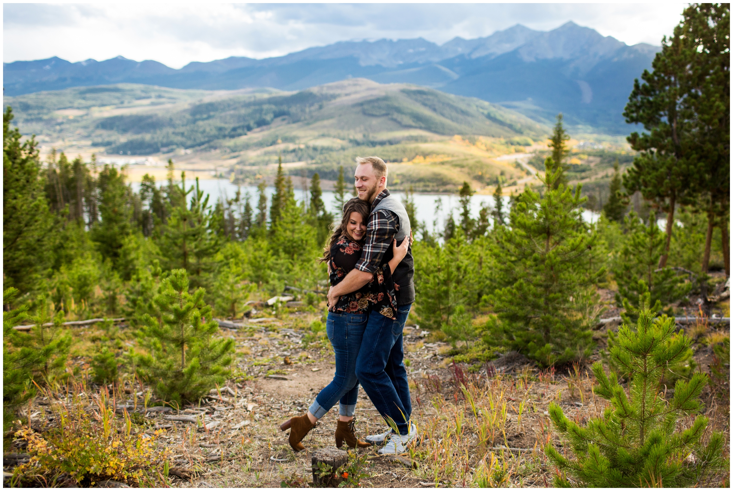couple hugging with mountains in background during Breckenridge engagement pictures at Sapphire Point