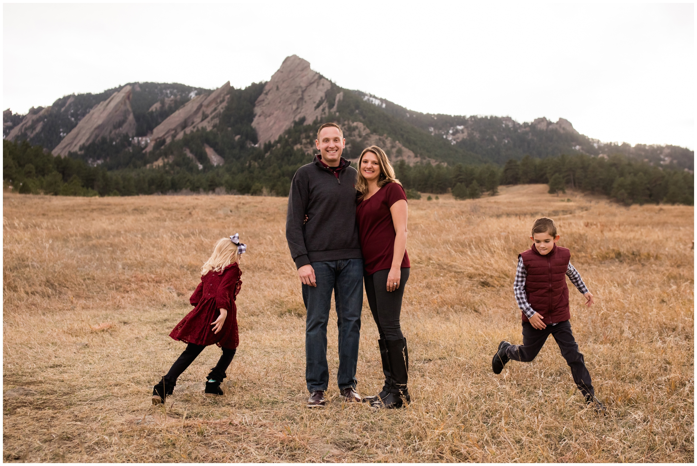 kids running around parents with flatirons in background during Chautauqua family pictures