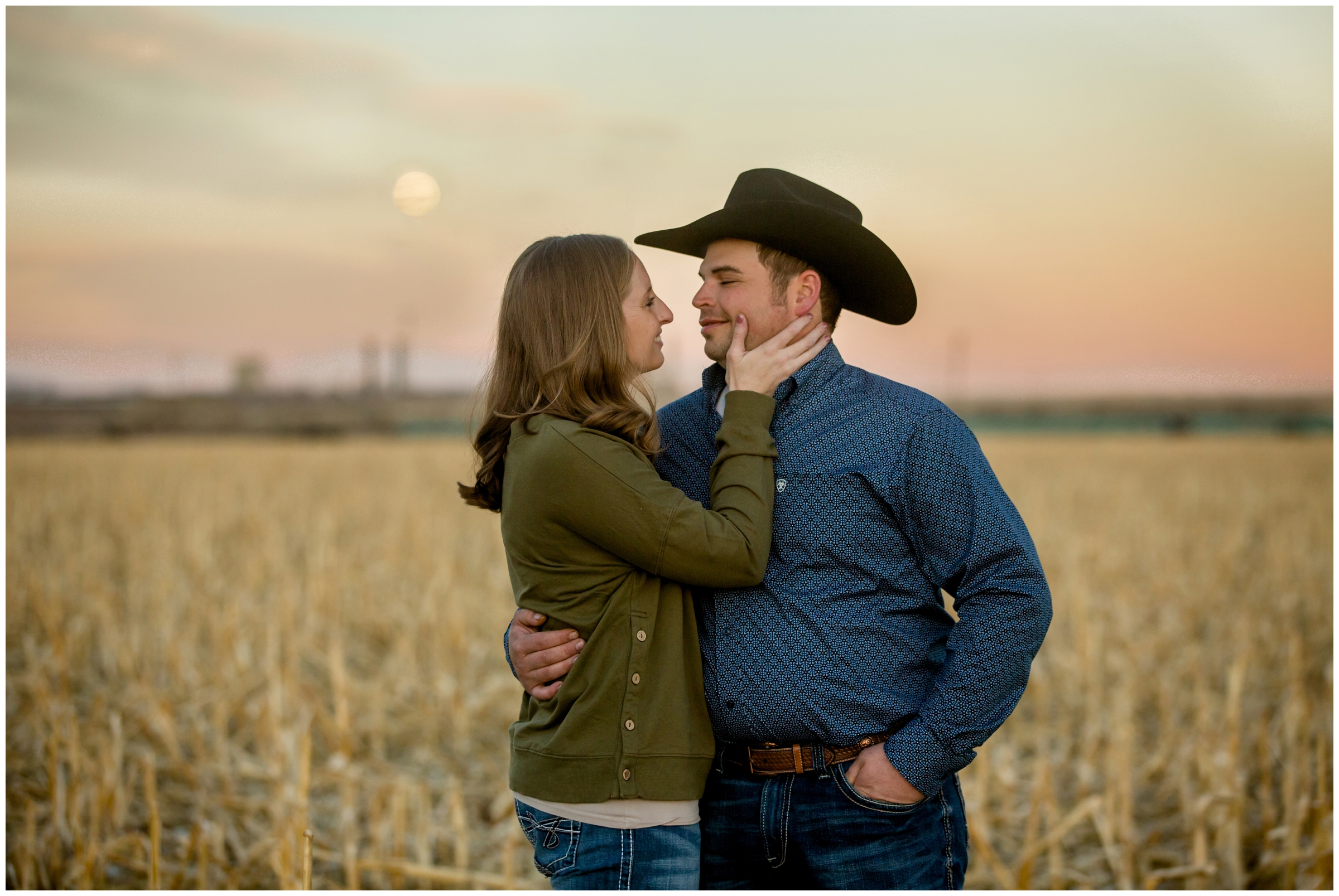 couple's portraits at sunset with moon in the sky