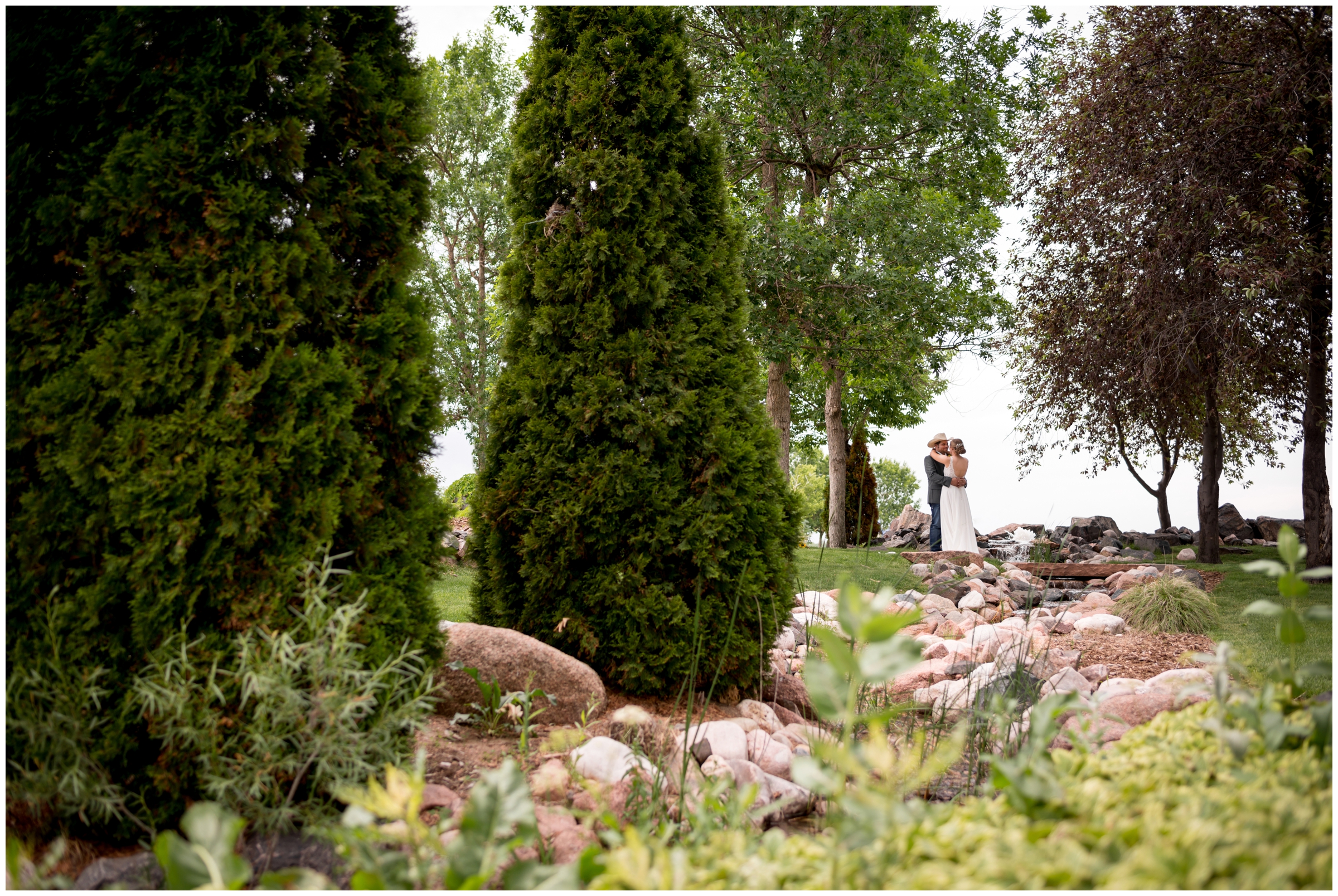 bride and groom embracing between the trees at their Colorado summer wedding 