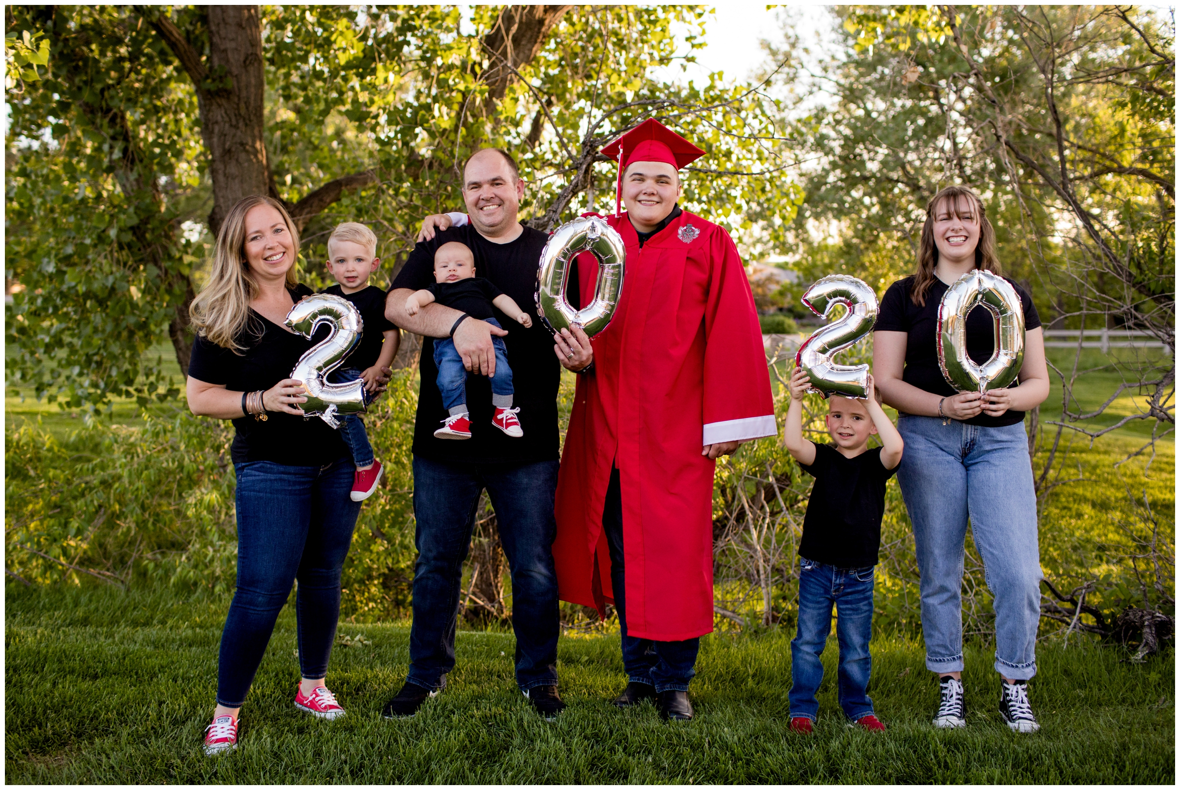 senior guy and family holding balloons during Colorado cap and gown graduation pictures 