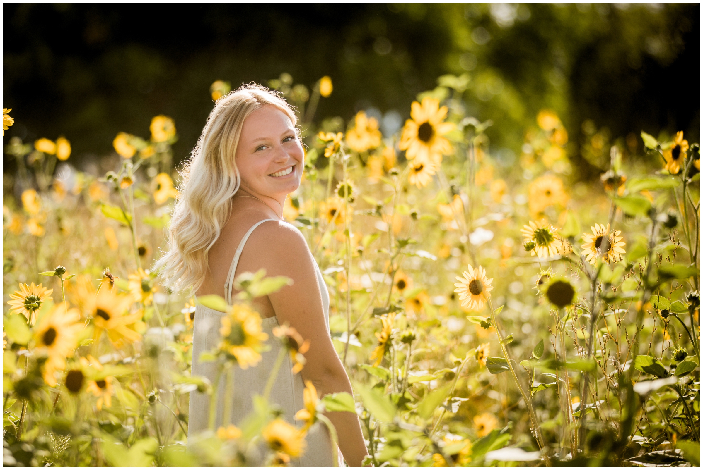 teen girl posing in sunflower field during Colorado senior pictures 