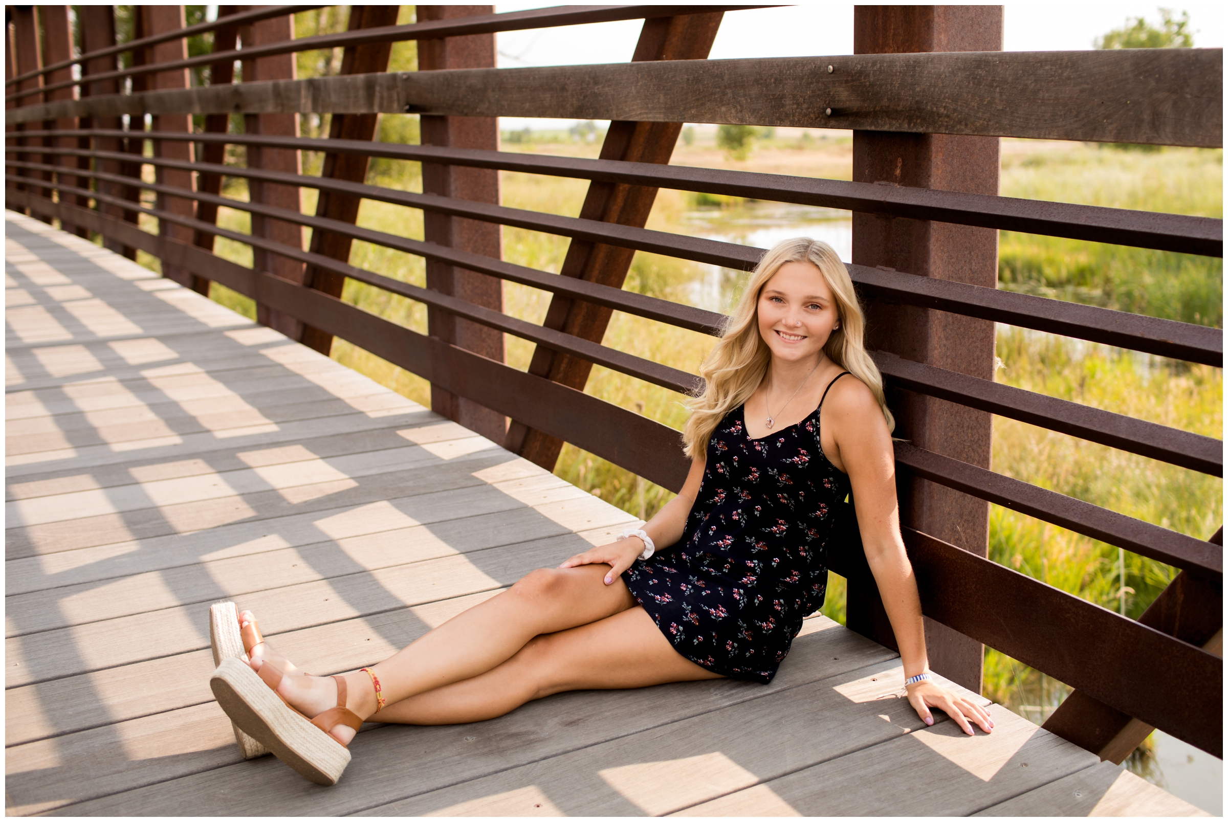 teen girl sitting on bridge during Longmont senior photos at Sandstone Ranch
