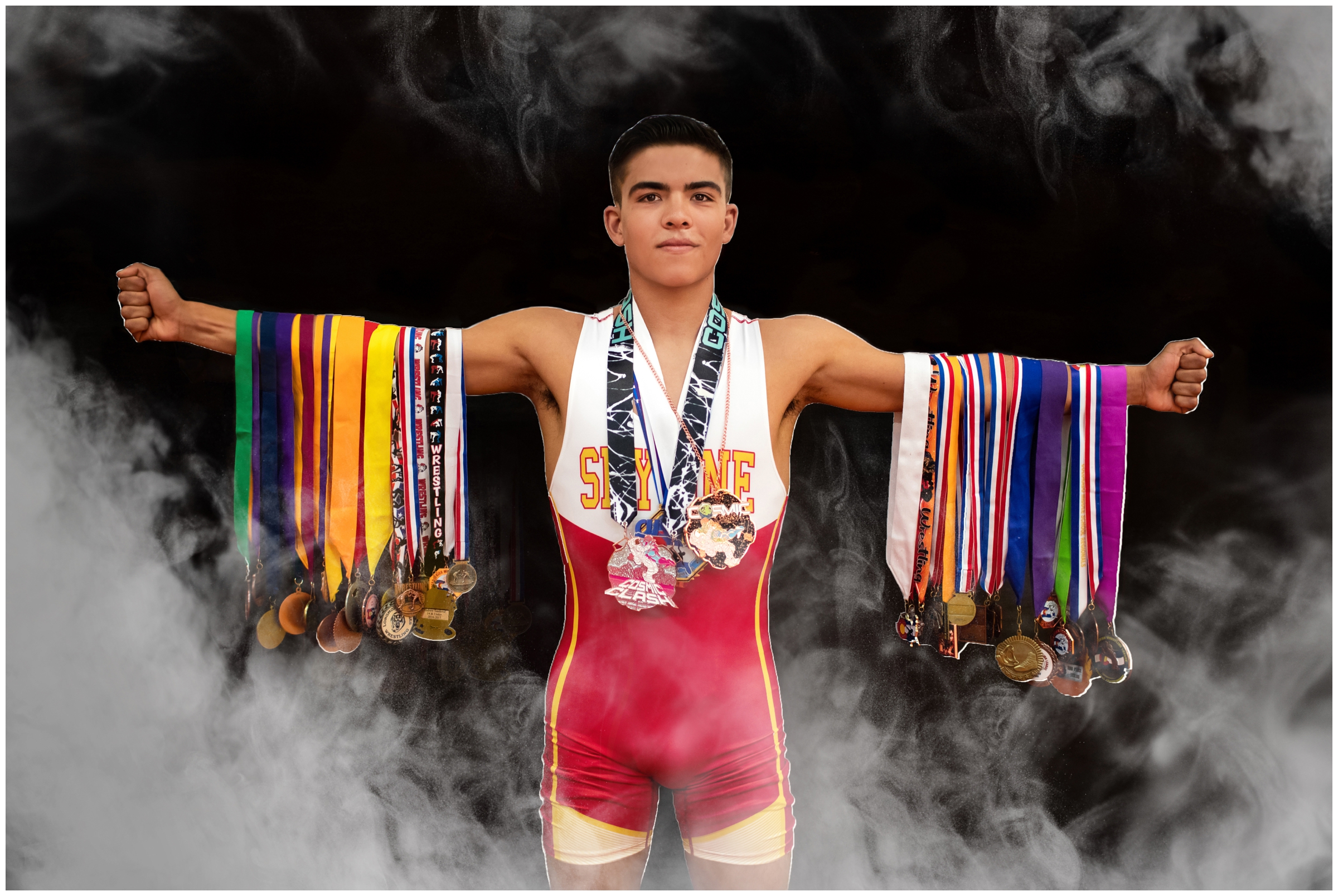 teen boy with medals on his arms during Colorado wrestling senior photos in Longmont