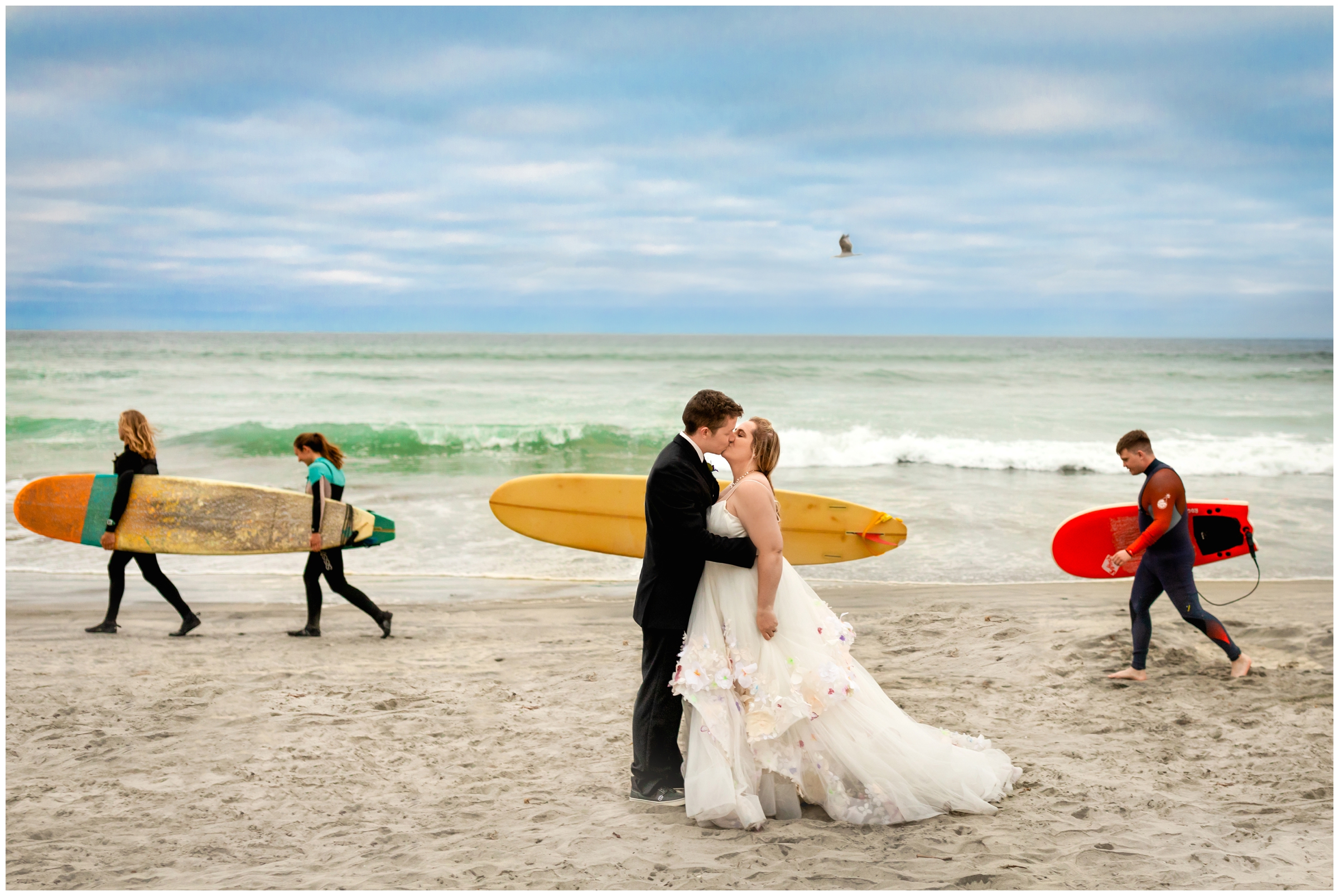 surfers and bride and groom in unique beach wedding photos in Carlsbad California