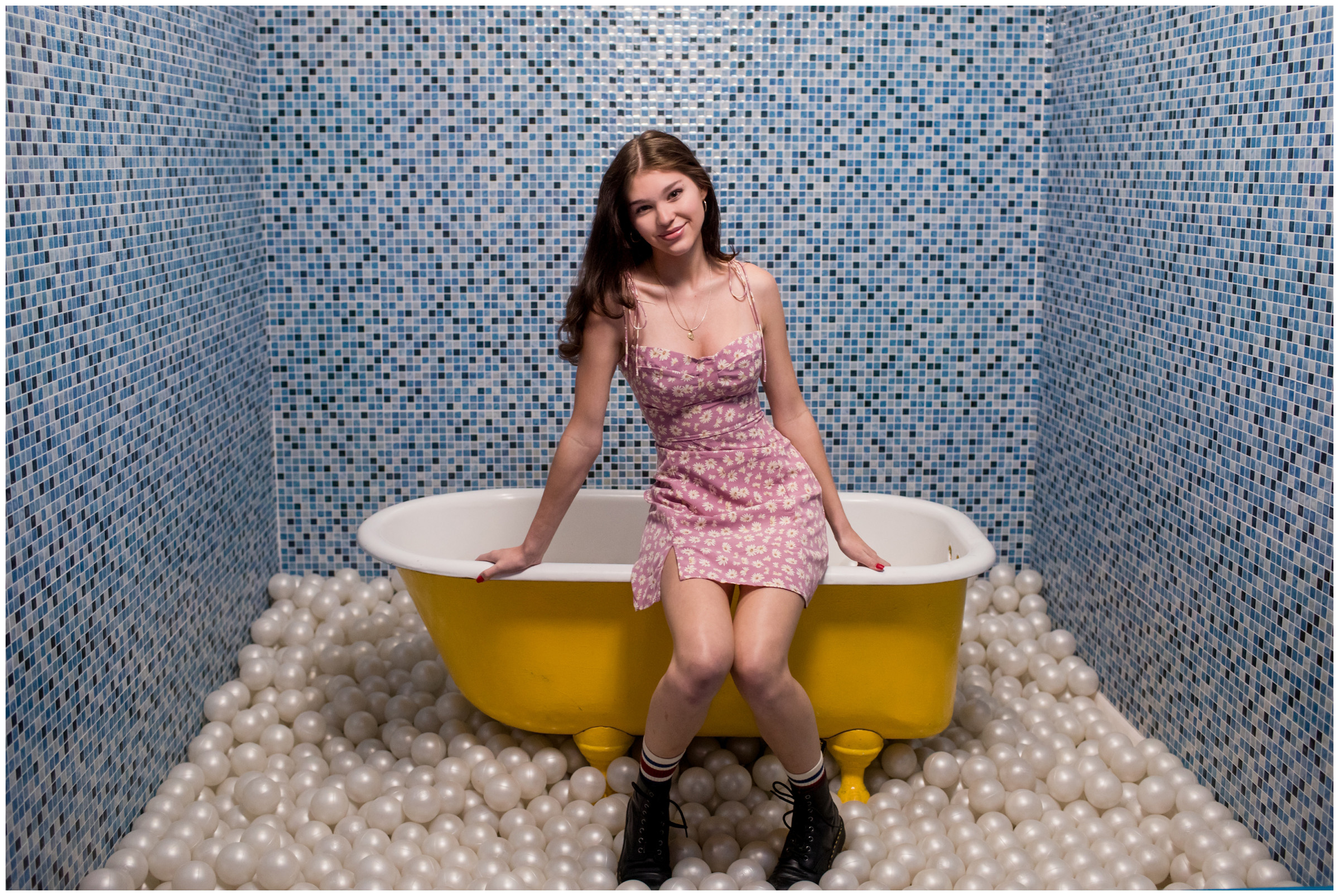 teen sitting on bathtub during unique senior photography session in Denver Colorado 