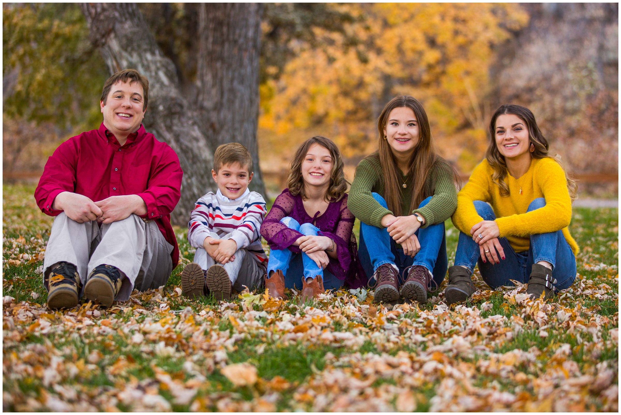 family sitting in leaves during Lyons Colorado fall family photos 