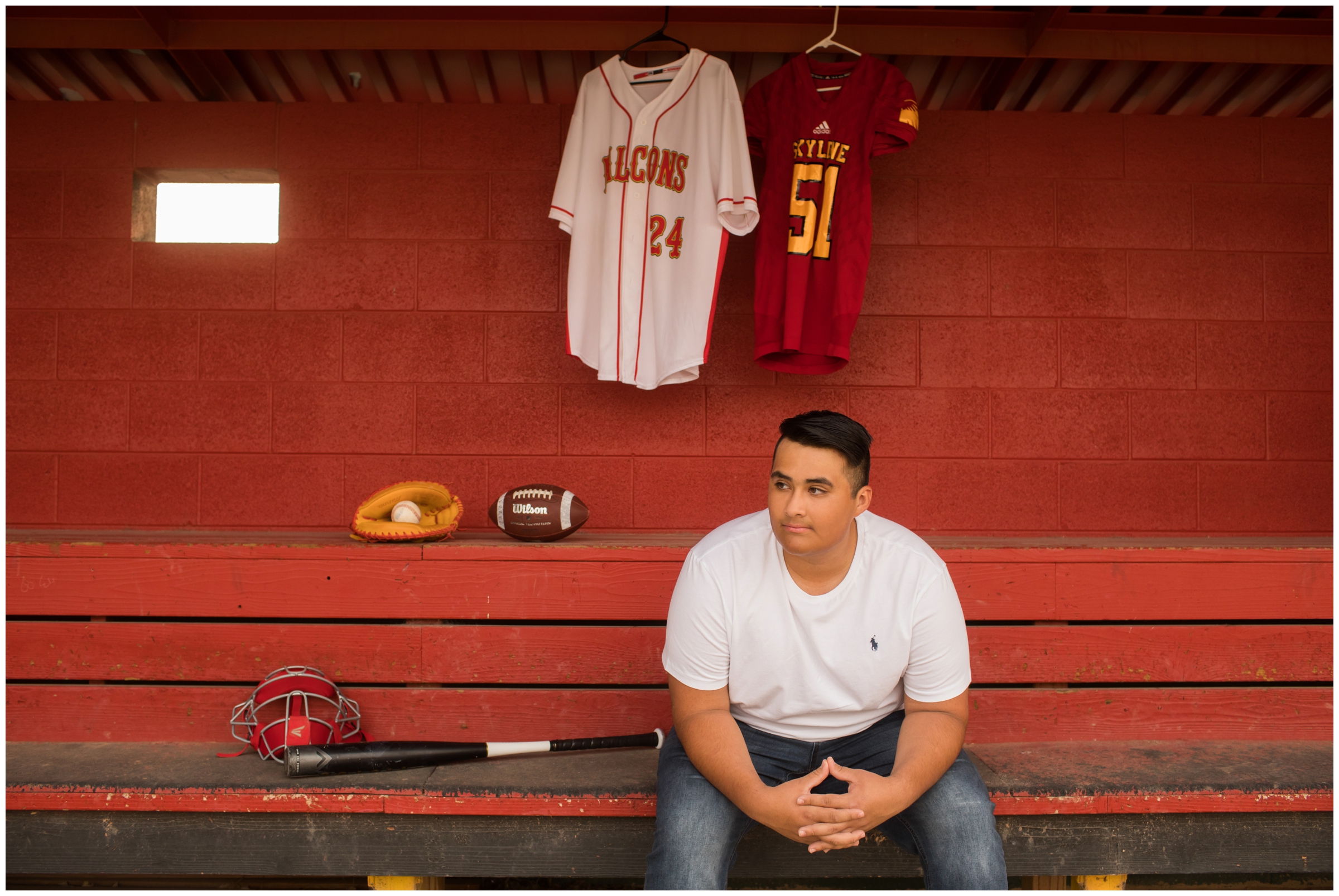 teen boy in baseball dugout during Longmont Colorado senior photos 