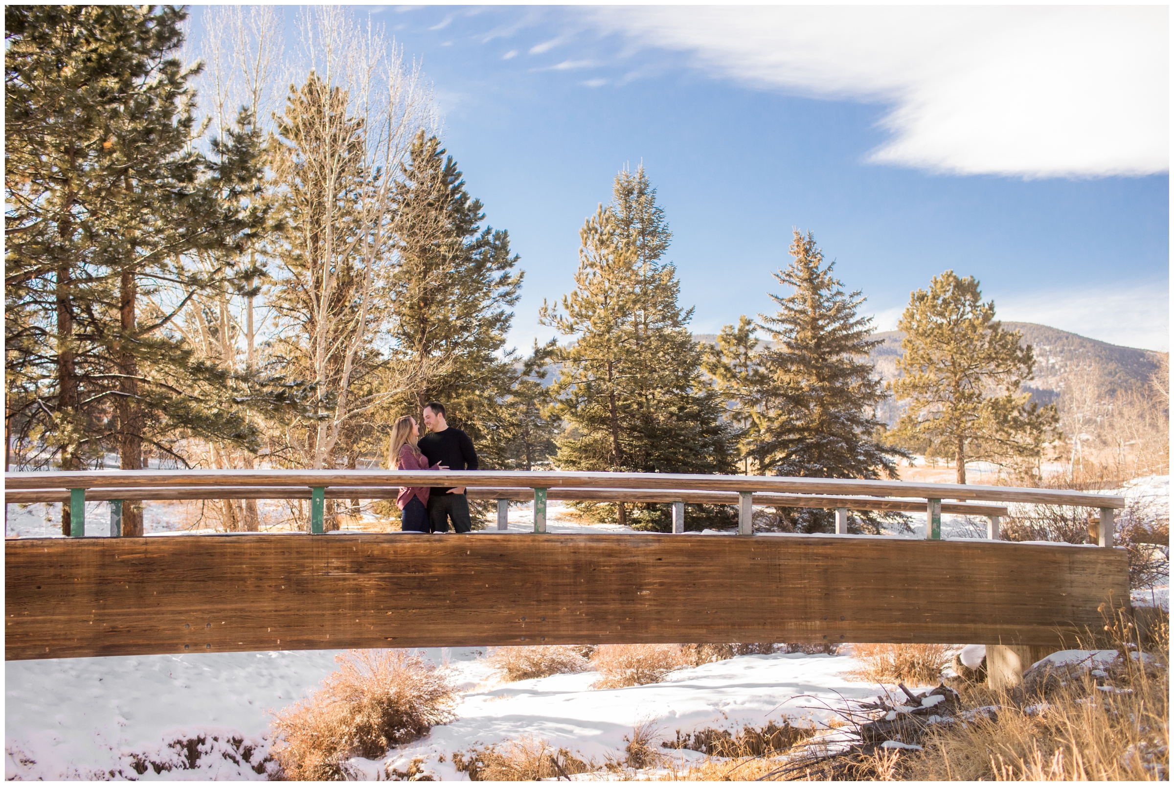 couple posing on wooden bridge during Colorado mountain engagement pictures 