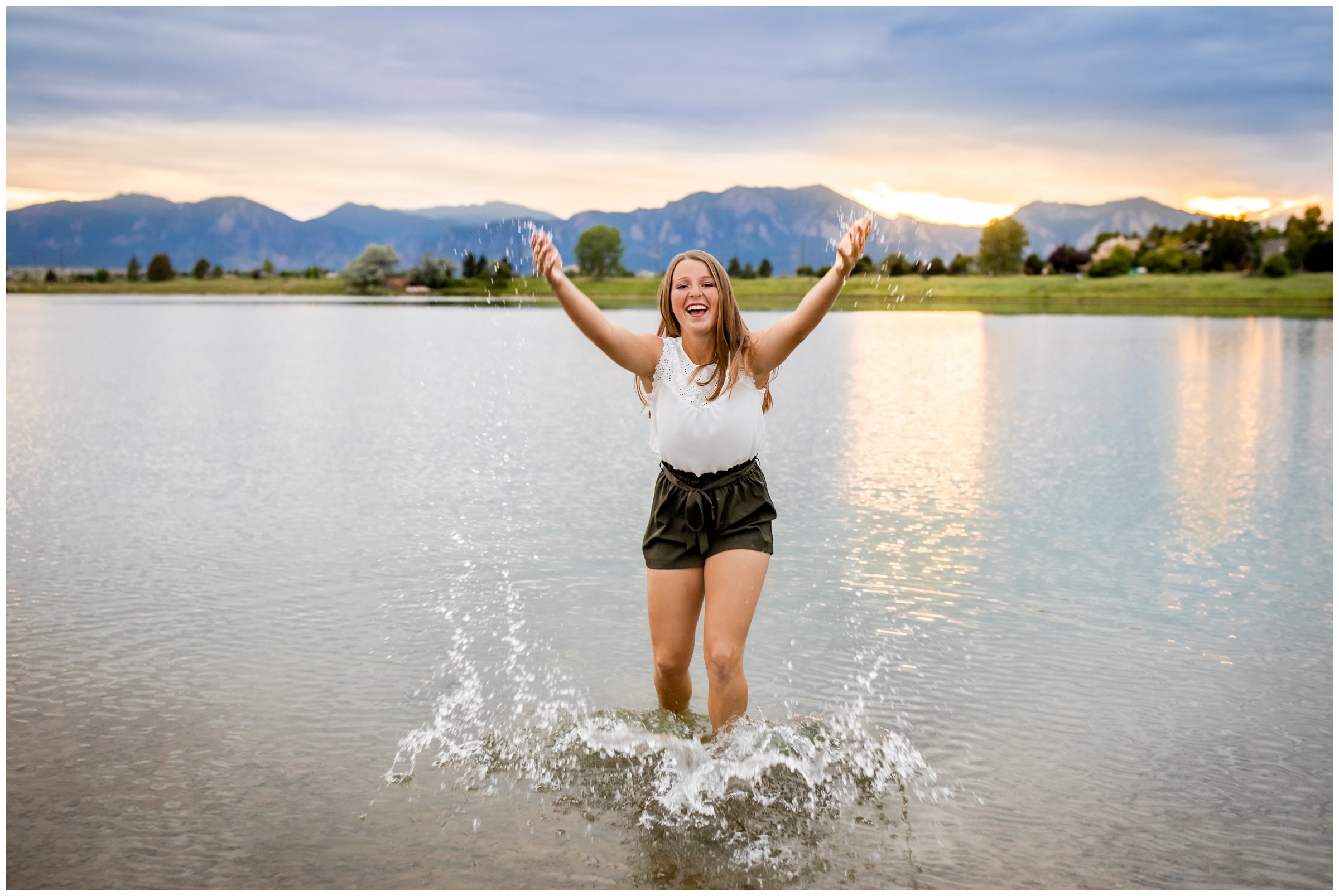 Teen standing in lake and splashing water during senior photos in Boulder Colorado