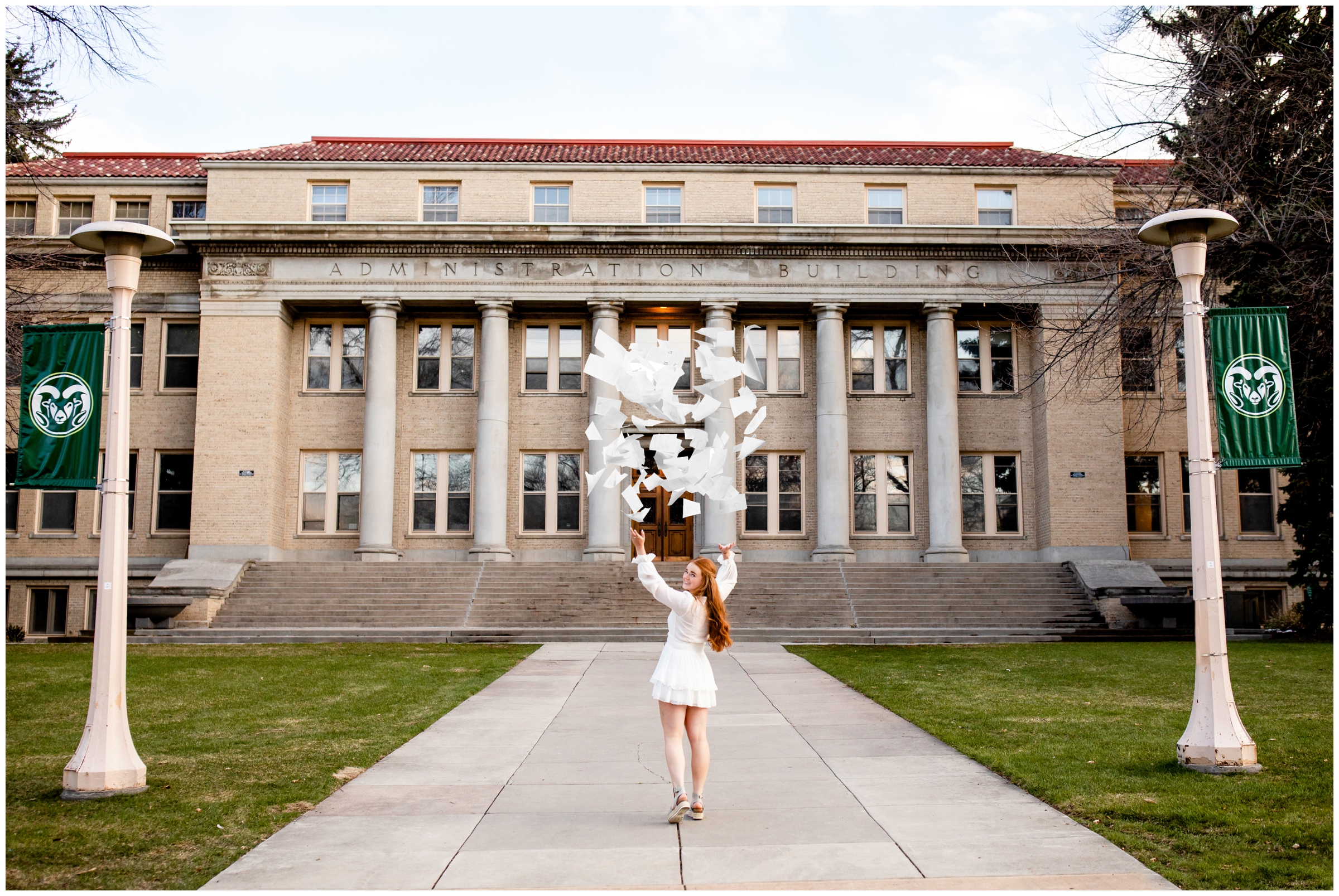 woman throwing papers in the air during CSU graduation senior photos in Fort Collins 