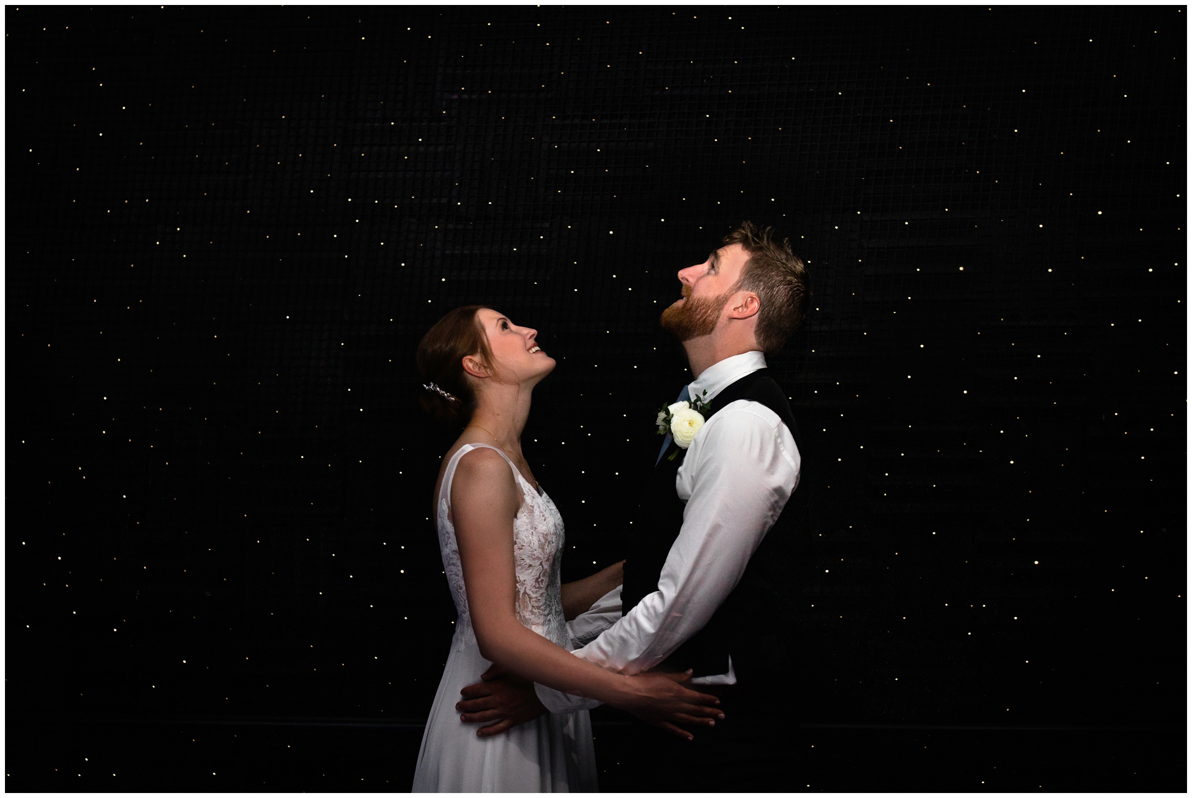 bride and groom in room of stars during Denver Museum of Nature and Science wedding portraits