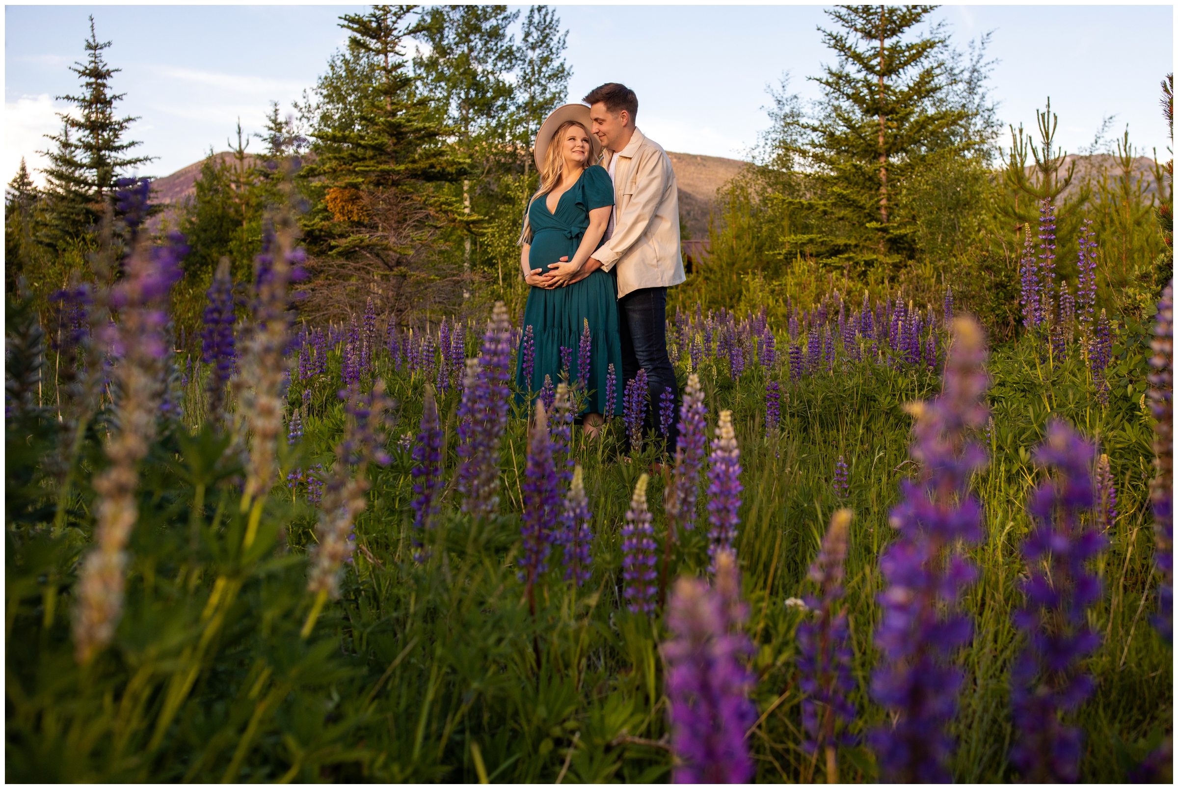 couple posing in wildflower field during Colorado mountain maternity photos in Grand Lake