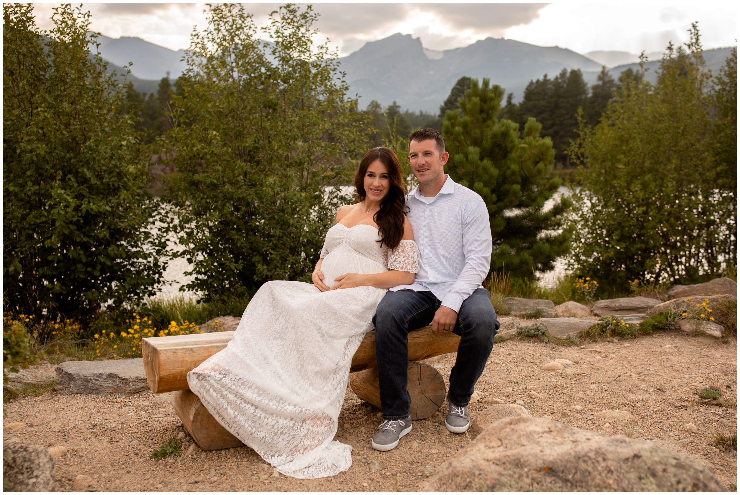 couple sitting on a bench at Sprague lake during Colorado mountain maternity photo shoot 