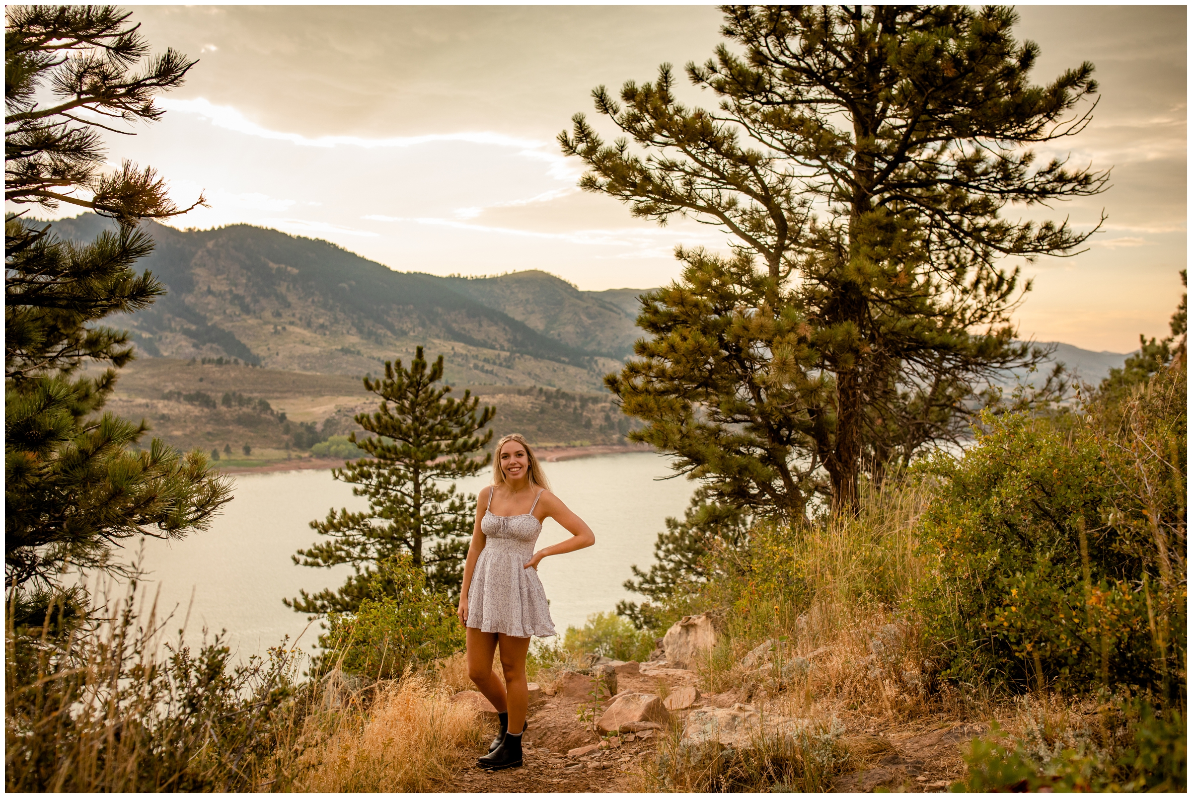 teen posing on a rock with mountains in the background at Horsetooth Reservoir Colorado graduation portraits 
