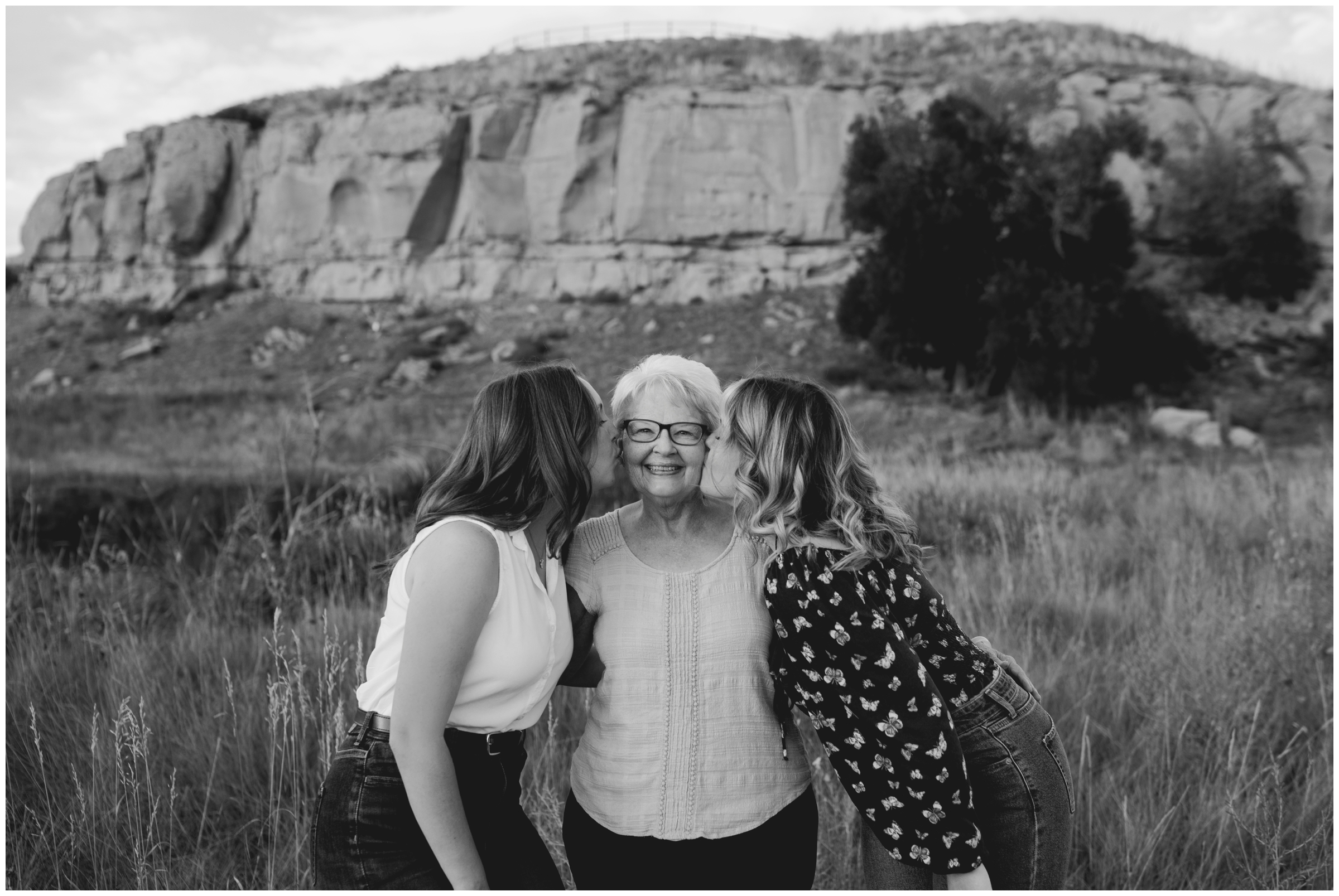 sisters kissing grandma on cheeks during Longmont extended family photos at Sandstone Ranch 