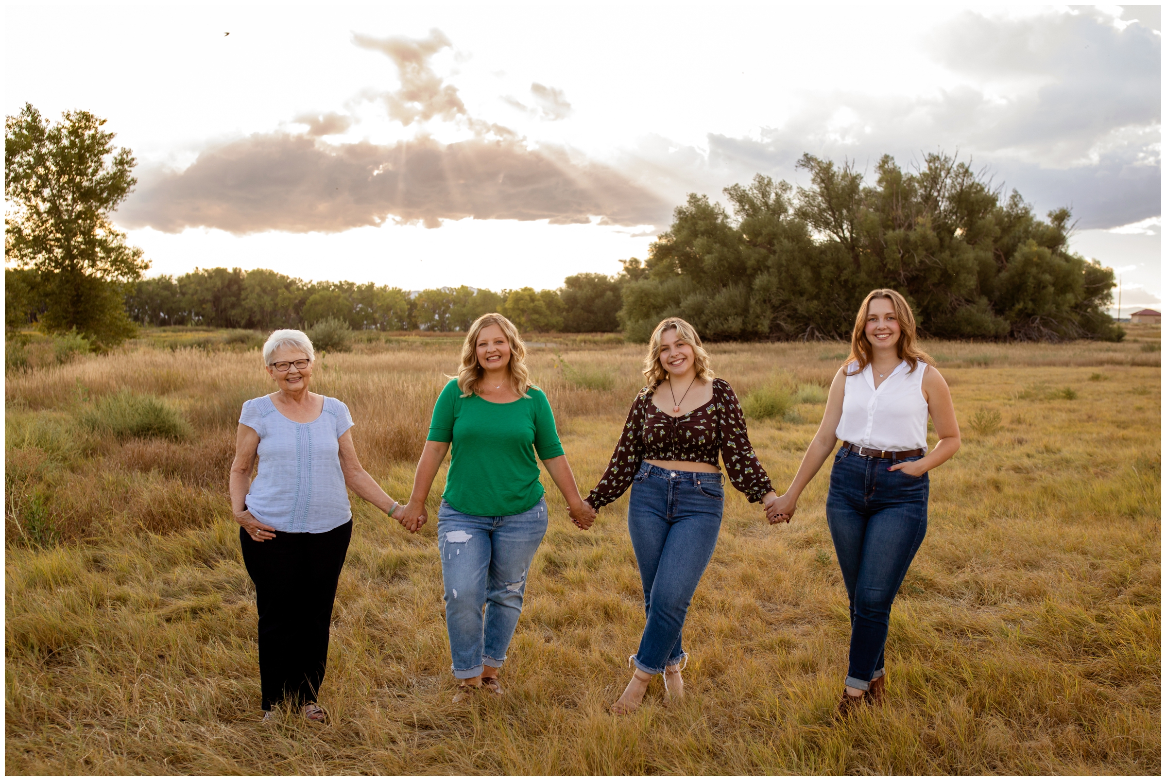 four generations of women posing in a field during Colorado extended family photos at Sandstone Ranch in Longmont
